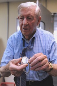 Billy Leonard shows a coin that was given to him by the Queen of the Netherlands in World War II during an interview at his store in downtown Charleston, S.C., June 9, 2010. Mr. Leonard served as an Army private in the 505th Regiment with the 82nd Airborne Division. (U.S. Air Force photo/James M. Bowman)