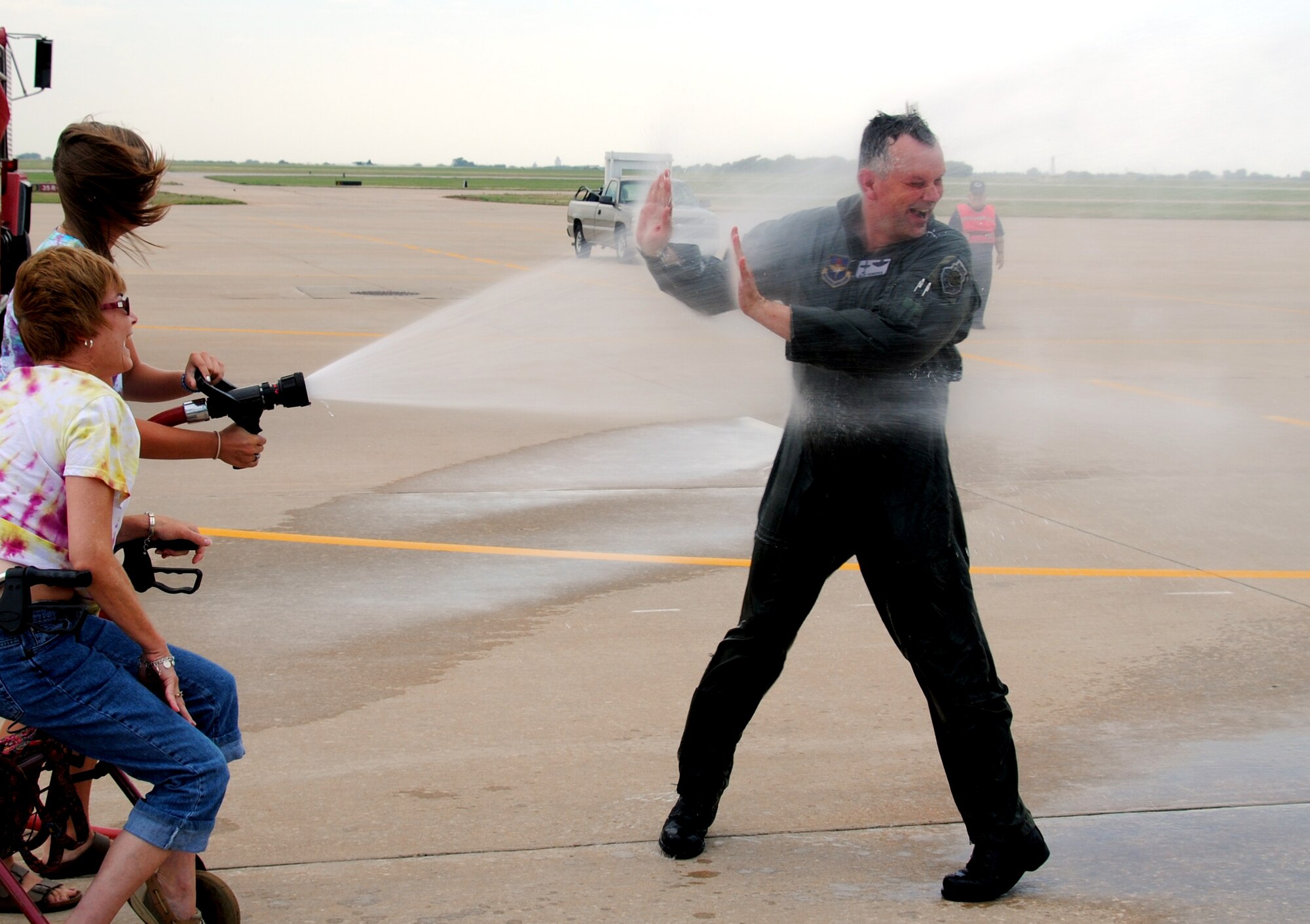 Col. Glen VanHerck is wet down with a fire hose by his daughter, Molly, holding the nozzle, and his wife, Marilyn, when he returned from his fini flight Friday, June 11. Colonel VanHerck, who served as both the 71st Operations Group commander, and the 71st Flying Training Wing vice commander during his assignment at Vance, took his last flight here in a T-6A Texan II assigned to the 8th Flying Training Squadron. He is being reassigned to the U.S. Strategic Command at Offutt AFB, Neb. (U.S. Air Force photo/ Bob Farrell)