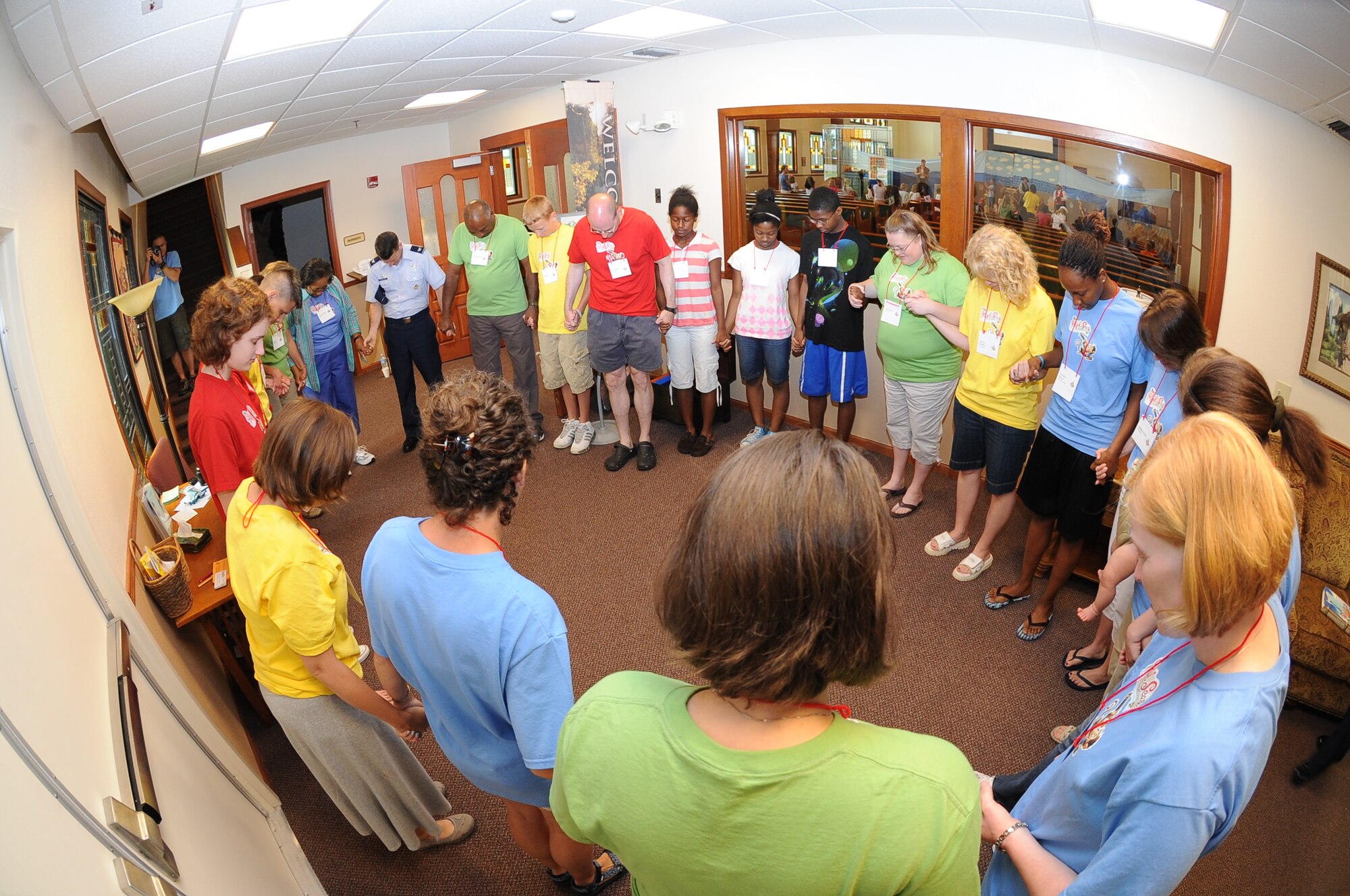 More than 25 volunteers pray before Vacation Bible School at the base chapel June 14, 2010, McConnell Air Force Base, Kan.  Vacation Bible School is just one of the many events the chapel sponsors throughout the year.  The programs assist the chapel corps team to fulfill their mission to “refuel the spirit of Team McConnell.”  (U.S. Air Force photo/Tech. Sgt. Chyrece Campbell) 