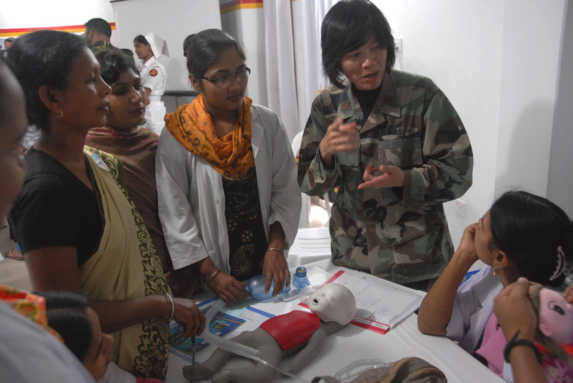 Maj. Chung Lee discusses resuscitative measures for infants with Bangladeshi health care providers during a subject matter expert exchange June 12, 2010, at the Smiling Sun Clinic in Jessore, Bangladesh. Major Lee is a nurse and international health specialist for the 13th Air Force at Joint Base Pearl Harbor-Hickam, Hawaii. (U.S. Air Force photo/1st Lt. Chris Hoyler)