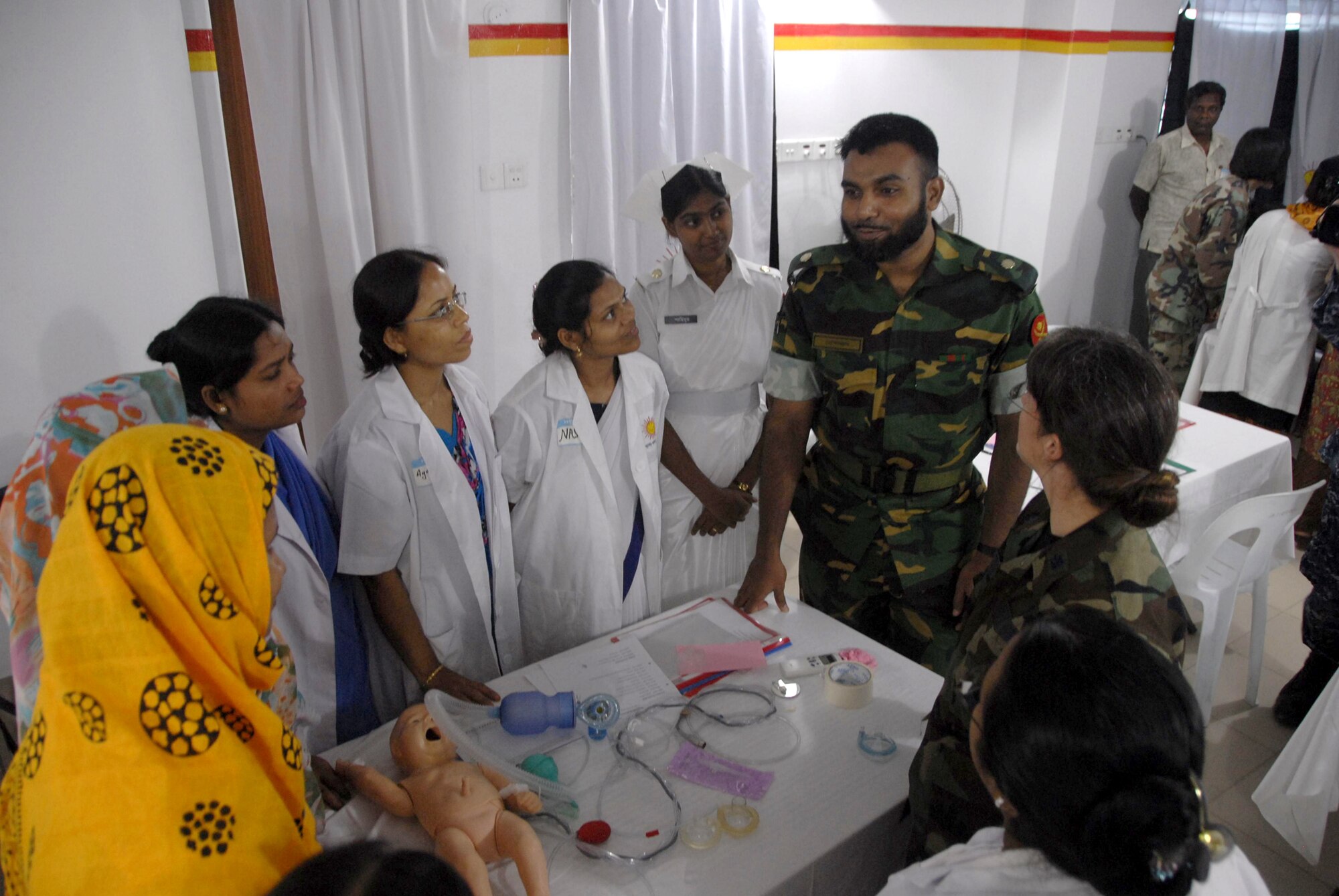 Maj. Mofazzol Hossain, left, and Lt. Col. Lindy Winter discuss neonatal care with Bangladeshi health care providers during a subject matter expert exchange June 12, 2010, at the Smiling Sun Clinic in Jessore, Bangladesh. Operation Pacific Angel is a joint and combined humanitarian assistance operation conducted in the Pacific area of responsibility to support U.S. Pacific Command's capacity-building efforts. Maj. Hossain is a Bangladesh Army pediatrician, and Colonel Winter is the chief of neonatology at the U.S. Naval Hospital on Camp Lester in Okinawa, Japan. (U.S. Air Force photo/1st Lt. Chris Hoyler)