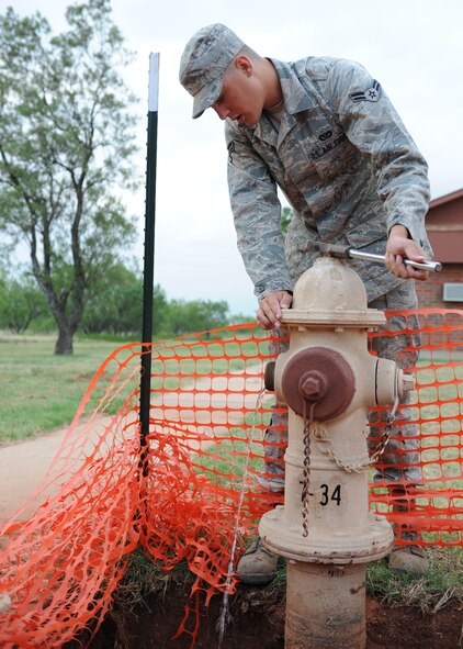 DYESS AIR FORCE BASE, Texas-- Airman 1st class Bryan Frees, 7th Civil Engineer Squadron water/fuels system maintenance journeyman, turns off a water valve so a fire hydrant can be replaced June 14 here. 7th CES supplies water to the entire base by continuously running water distribution systems and responding to any mishaps involving the base water system. 7th CES is also responsible for fuel distribution that supplies aircraft on the base. (U.S. Air Force photo/ Airmen 1st Class Brittney Smolinski)