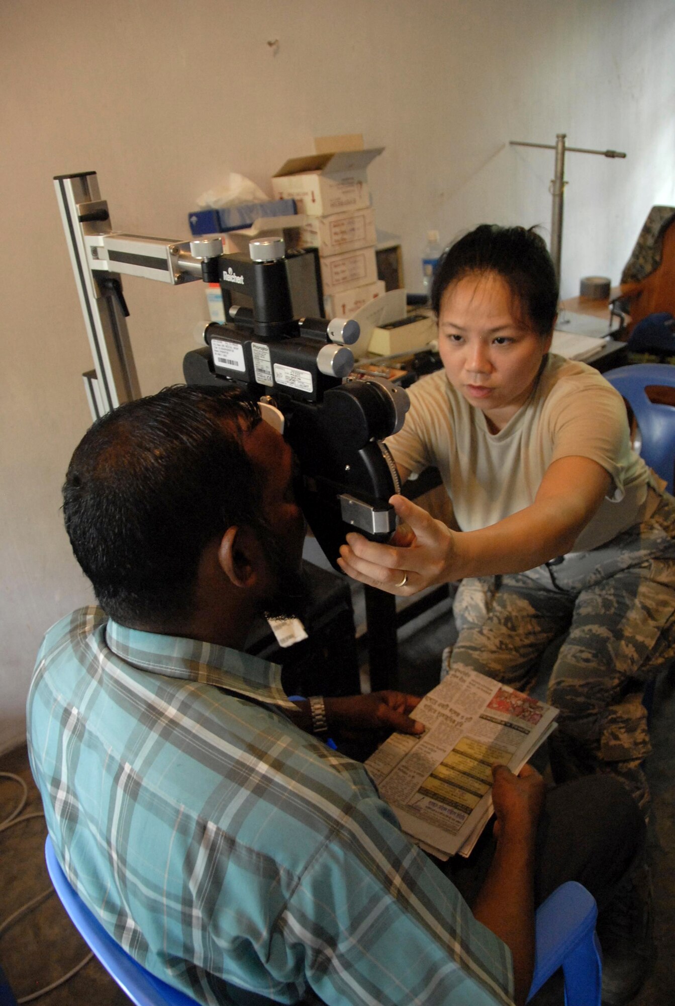 Maj. Thuy Tran administers an eye exam to a Bangladeshi citizen June 13, 2010, at Monirampur Regional Training Center in Jessore, Bangladesh, as part of Operation Pacific Angel. Operation Pacific Angel is a joint and combined humanitarian assistance operation conducted in the Pacific area of responsibility to support U.S. Pacific Command's capacity-building efforts. Major Tran is an optometrist from the Oregon Air National Guard. (U.S. Air Force photo/1st Lt. Chris Hoyler)