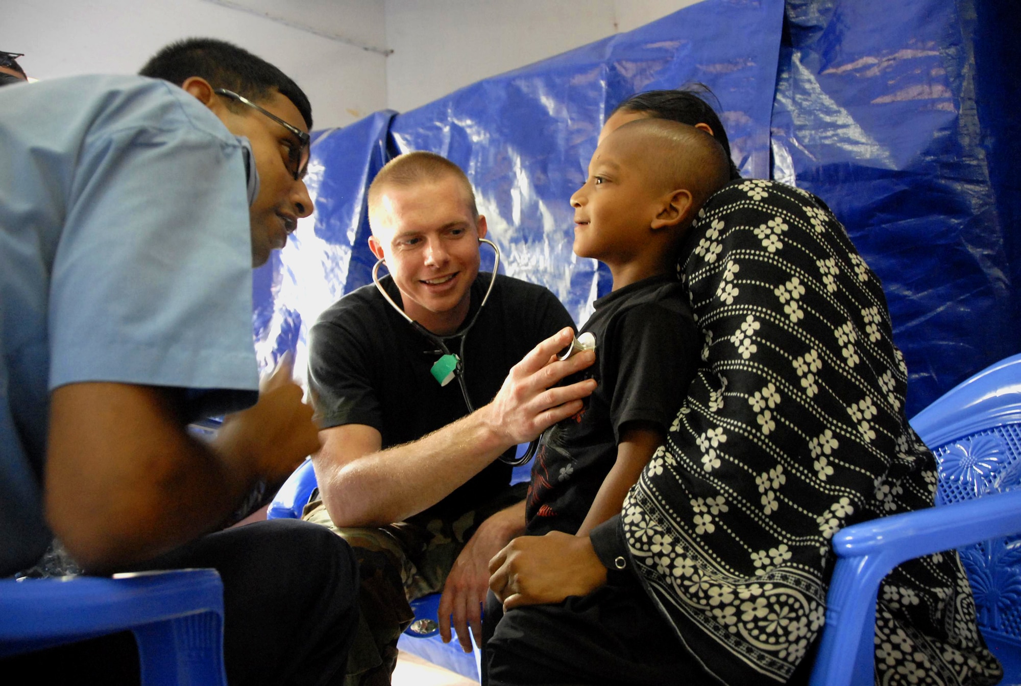 Capt. David Belcher (center) examines a young Bangladeshi boy while a translator from the Bangladesh air force speaks with the patient June 13, 2010, in Jessore, Bangladesh, as part of Operation Pacific Angel. Operation Pacific Angel is a joint and combined humanitarian assistance operation conducted in the Pacific area of responsibility to support U.S. Pacific Command's capacity-building efforts. Captain Belcher is a general care physician from the 3rd Medical Group at Elmendorf Air Force Base, Alaska. (U.S. Air Force photo/1st Lt. Chris Hoyler)