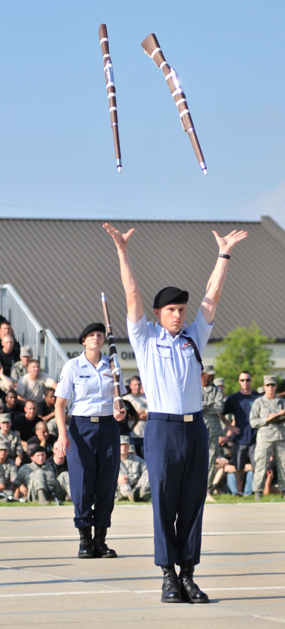 Airman 1st Class Brett Williams tosses his rifles during the Bulls’ third place freestyle performance as Airman 1st Class Danielle Leins looks on.  (U.S. Air Force photo by Adam Bond)
