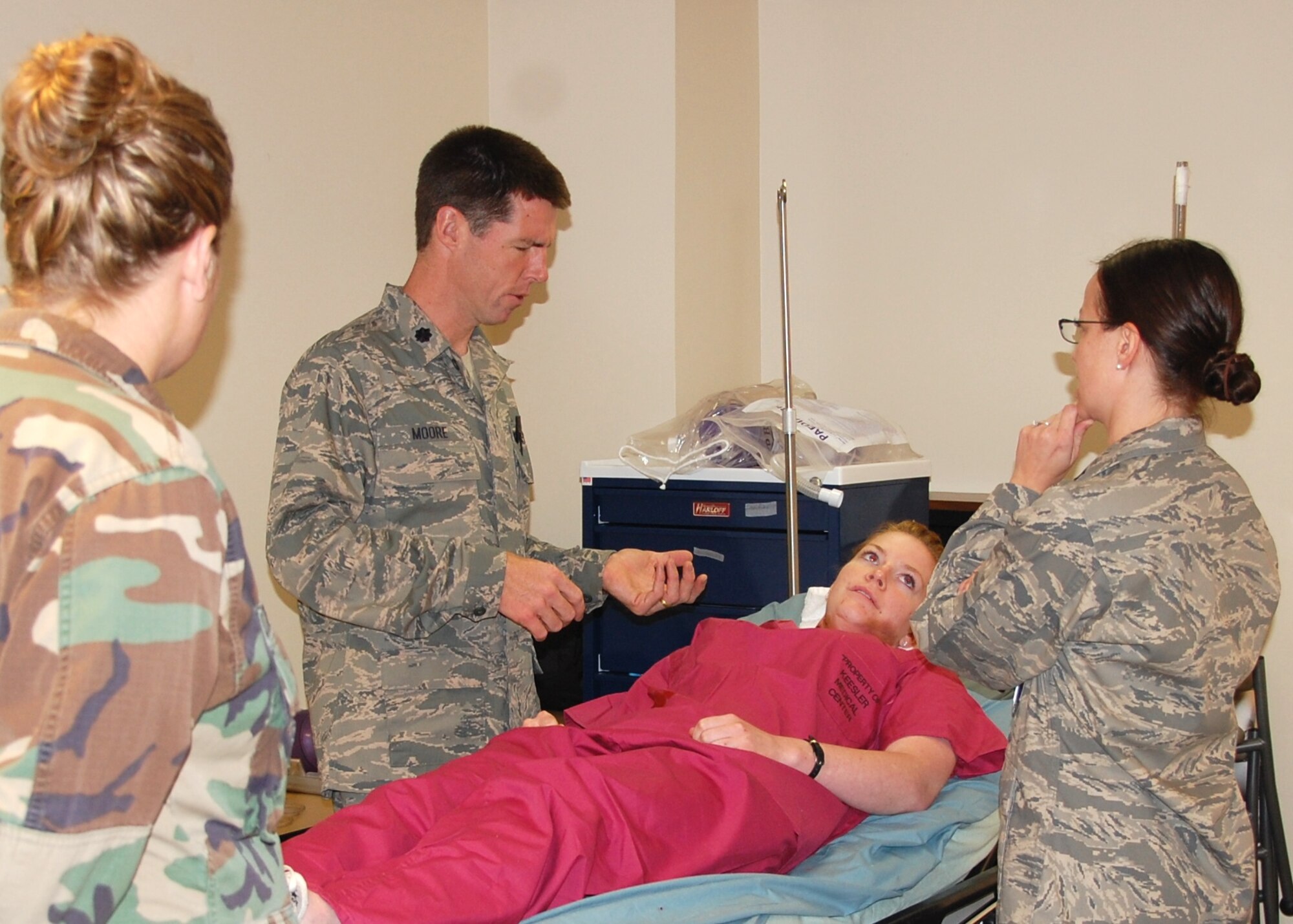 Colonel Moore discusses his patient’s symptoms as Captain Freeman and Major Rippon observe.  Airman Gina Brown, an aerospace medical apprentice Phase II course student, was the “patient.”  (U.S. Air Force photo by Steve Pivnick)
