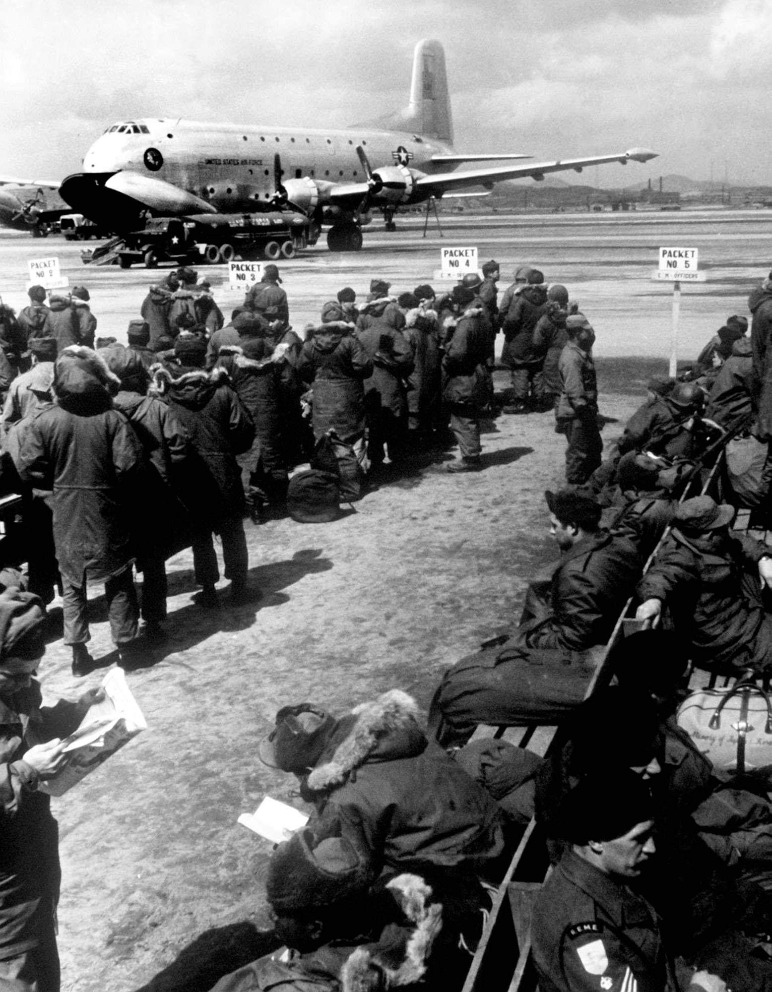 Because Japan was nearby and safe, troops could periodically enjoy 5-day rest and relaxation leaves there. These troops await USAF transport on a C-124 to Japan. (U.S. Air Force photo)