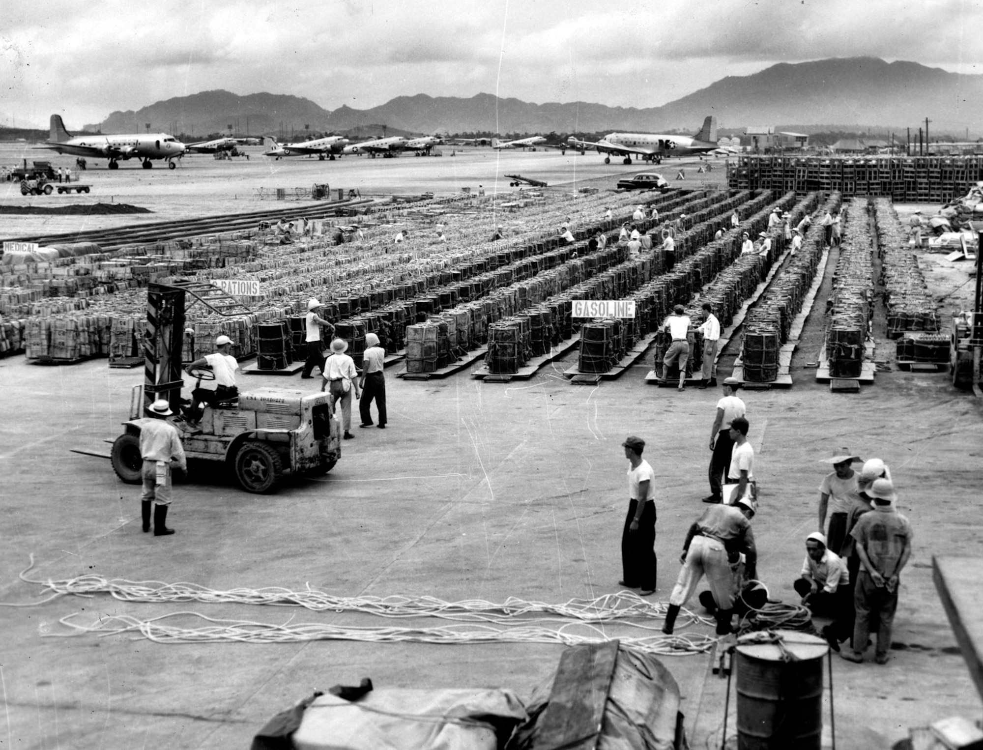 Supplies stand ready at an air base in Japan. This food and fuel will be loaded onto C-119s and dropped to front-line forces. (U.S. Air Force photo)