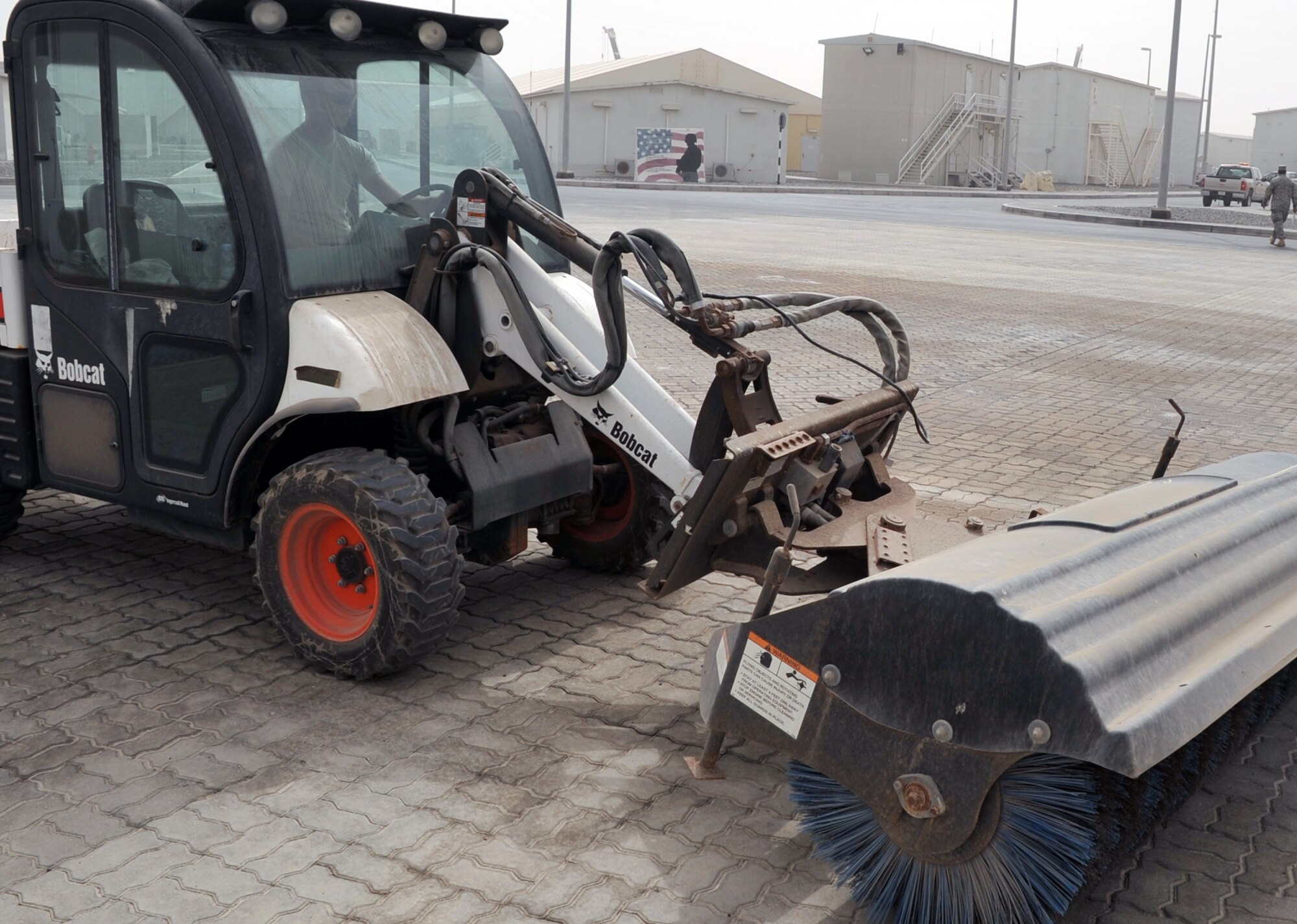 Airman 1st Class James Oldenhoff, pavements and construction equipment journeyman with the 380th Expeditionary Civil Engineer Squadron, uses a sweeper to clean an area of the 380th Air Expeditionary Wing compound at a non-disclosed base in Southwest Asia on June 12, 2010. Airman Oldenhoff is deployed from the 786th Civil Engineer Squadron at Ramstein Air Base, Germany, and his hometown is Wisconsin Dells, Wisc. (U.S. Air Force Photo/Master Sgt. Scott T. Sturkol/Released)