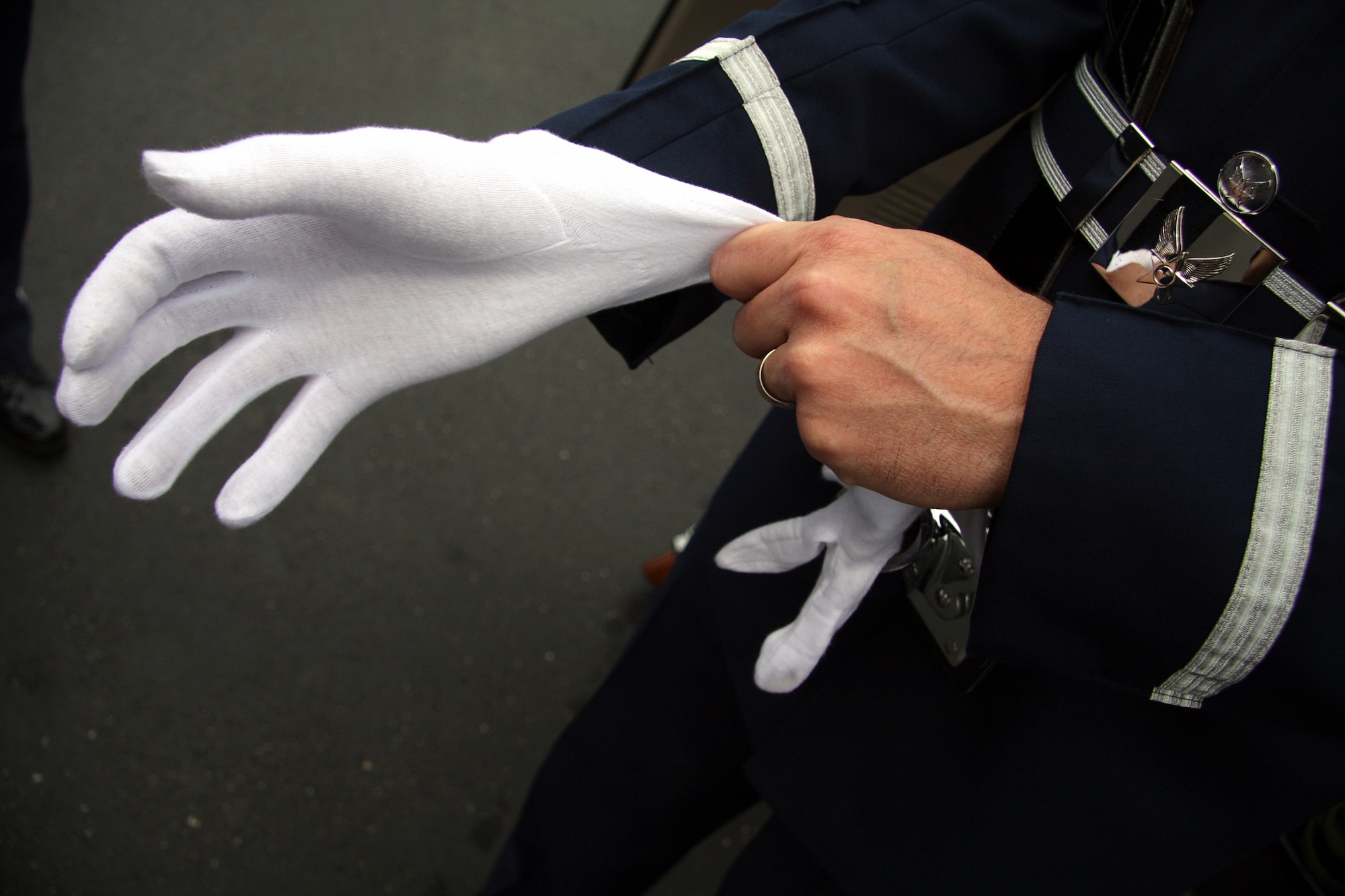 GRISSOM AIR RESERVE BASE, Ind. -- Staff Sgt. Ben Durr, a member of the Grissom Base Honor Guard, pulls on a white glove as he prepares to present the Colors at a opening ceremony for a new Veteran's Affairs clinic in Peru, Ind., June 8. Honor guard members pay special attention to their uniforms as they represent the United States Air Force and Grissom in the community. Sergeant Durr is a member of the 434th Security Forces Squadron. (U.S. Air Force photo/Tech. Sgt. Mark R. W. Orders-Woempner)