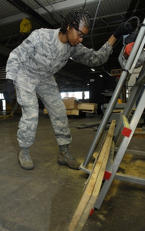 Senior Airman Samantha Jean cuts a piece of wood which will be used to build a pallet at Joint Base Charleston, S.C., June 16, 2010. The pallet will contain parts and supplies for forklifts that are currently in need of repair. Each pallet takes roughly 15 minutes to complete and once the shipment has been packed on, it must go through a series of inspections and processing systems to ensure the supplies arrive at their destination in a timely manner. Airman Jean is a traffic management apprentice with the 437th Aerial Port Squadron. (U.S. Air Force Photo/Airman 1st Class Lauren Main)