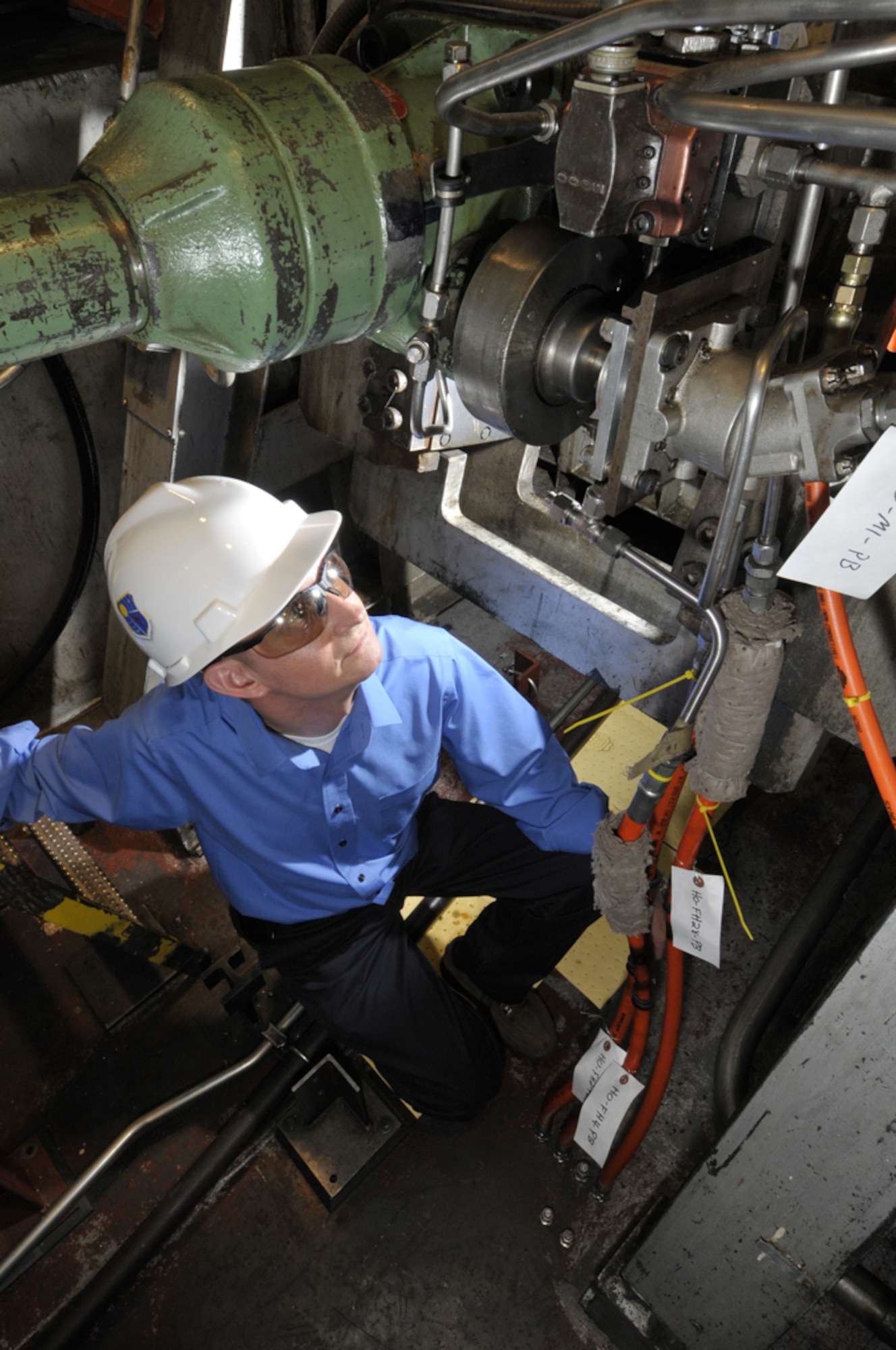 Christopher Abbott, program manager with the 650th Test Evaluation Systems Squadron, examines the mechanical hardware underneath the 4-foot transonic wind tunnel at the Propulsion Wind Tunnel facility.  His Investments project will reduce lost test time and improve reliability. (Photo by Rick Goodfriend)