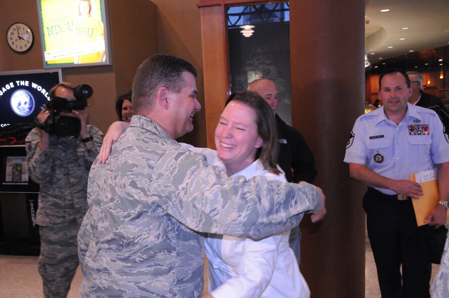 Lt.Col. Dan Bertsch, a staff judge advocate with the 119th Wing, North Dakota National Guard, hugs Master Sgt. Maria Overn at Hector International Airport in Fargo on June 11.  He was greeted by friends and family at the airport after returning home from a year-long deployment in Afghanistan, prior to that he served in Iraq for seven months.  In the last two years, Bertsch has been deployed more than 18 months; this was his 14th voluntary deployment since Sept. 11, 2001.