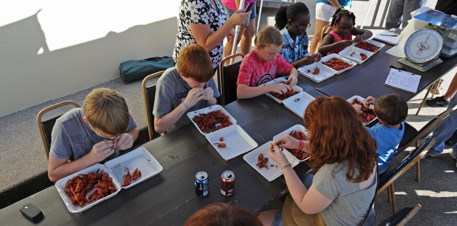 BARKSDALE AIR FORCE BASE, La. – Children dig in as fast as they can to eat as many crawfish as they can in two minutes during the Kid’s Crawfish Eating Contest at the Barksdale Crawfish Festival, June 11. (U.S. Air Force photo by Senior Airman Alexandra M. Boutte) (RELEASED)