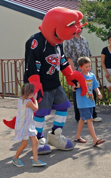 BARKSDALE AIR FORCE BASE, La. – Clawed, the official mascot of the Mudbugs of Bossier- Shreveport Hockey Team, walk with James Isenhour Jr.,6, and his sister Calli, 4, during the Barksdale Crawfish Festival, June 11. Children attending the festival participated in a crawfish race and a crawfish eating contest for door prizes. James and Calli are the children of James Isenhour, 2d Maintenance Squadron. (U.S. Air Force photo by Senior Airman Alexandra M. Boutte) (RELEASED)