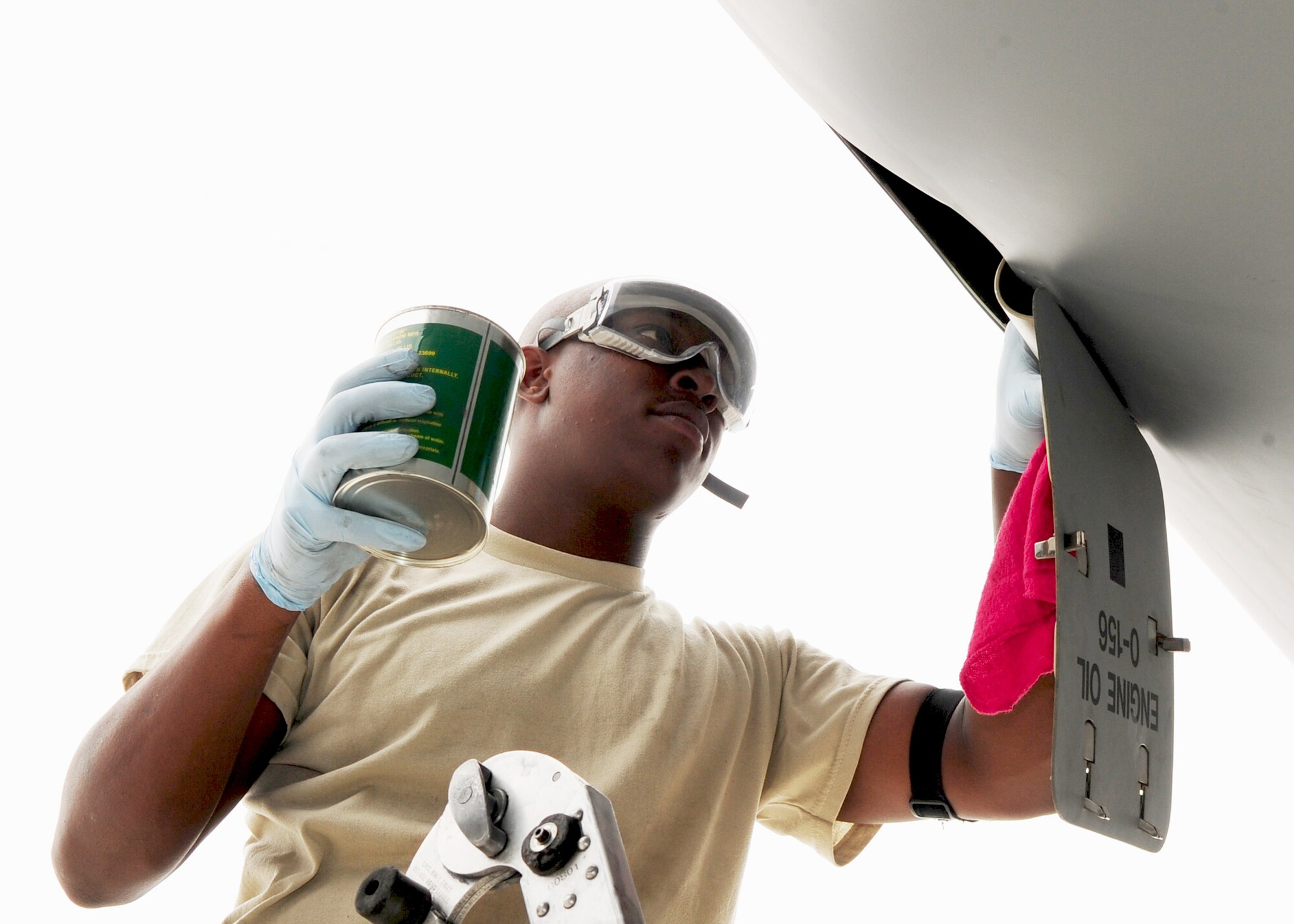Senior Airman Alexander Mack, 376th Expeditionary Aircraft Maintenance Squadron jet engine mechanic, puts engine oil in a C-17 Globemaster III after its arrival to the Transit Center at Manas, Kyrgyzstan, June 8, 2010. Airman Mack is deployed here from the 437th Aircraft Maintenance Squadron, Charleston Air Force Base, S.C. (U.S. Air Force photo/ Senior Airman Nichelle Anderson/ released)