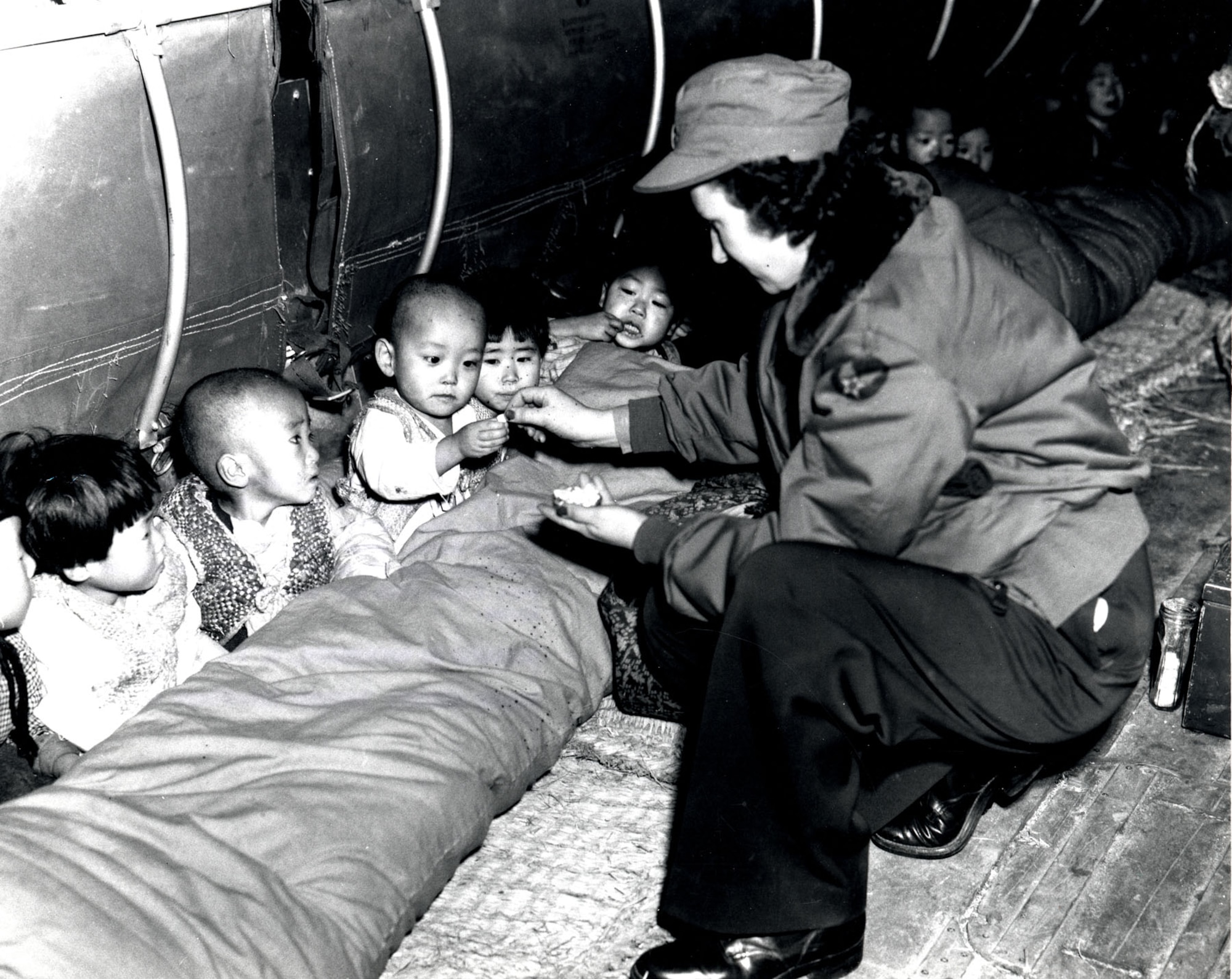 Flight nurse Capt. Mary Spivak hands out candy to orphans during the evacuation. (U.S. Air Force photo)