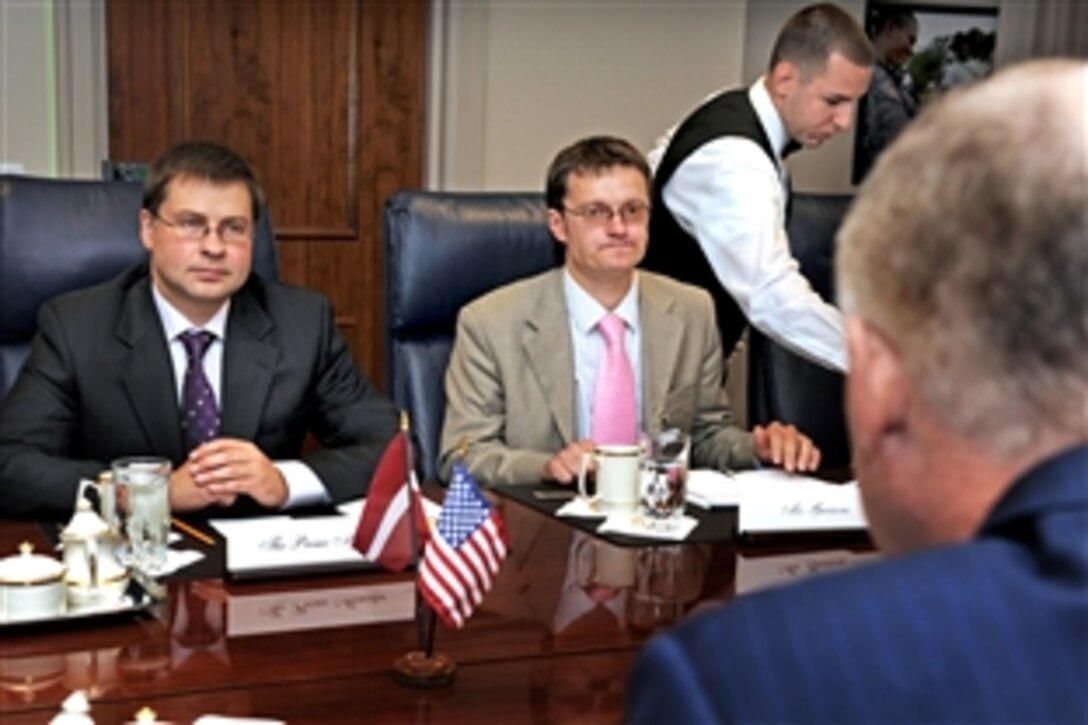 As coffee is being served, a Pentagon meeting gets underway between Latvian Prime Minister Valdis Dombrovskis, left, and Deputy Defense Secretary William J. Lynn III, right foreground, June 16, 2010. Accompanying Dombrovskis is Latvian Policy Director Janis Garisons, center.