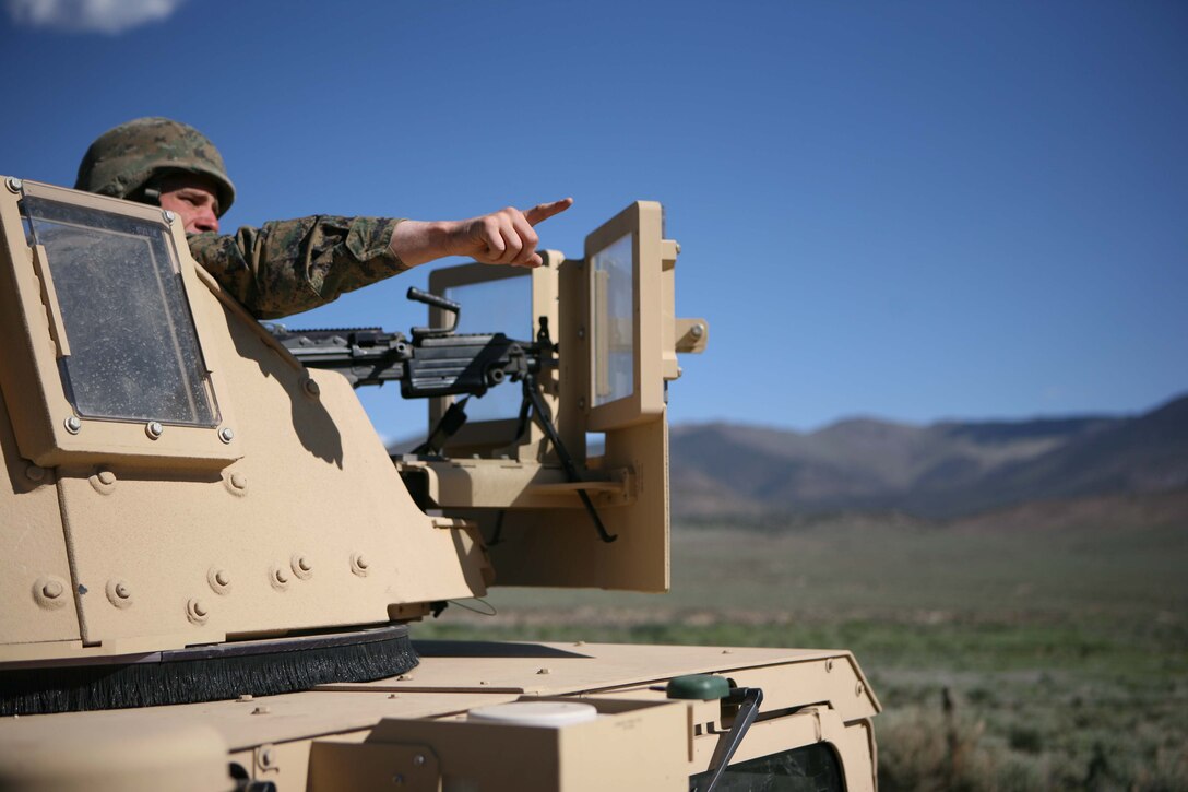 Lance Cpl. Mark Deluca, a squad automatic weapon gunner with 1st Battalion, 25th Marine Regiment, points out the location of a possible improvised explosive device during a training scenario June 16.
