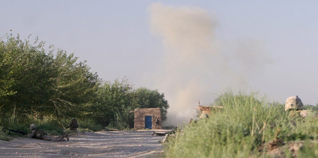 Marines from India Company, 3rd Battalion, 6th Marine Regiment, and soldiers from the Afghan National Army take cover and provide security following an improvised explosive device blast in Marjah, Helmand province, Afghanistan, June 18, 2010. During the patrol, the troops cleared a southeastern sector within India Company’s area of operation, looking for weapons caches, IED factories and insurgents. This particular sector is notorious for its Taliban presence.