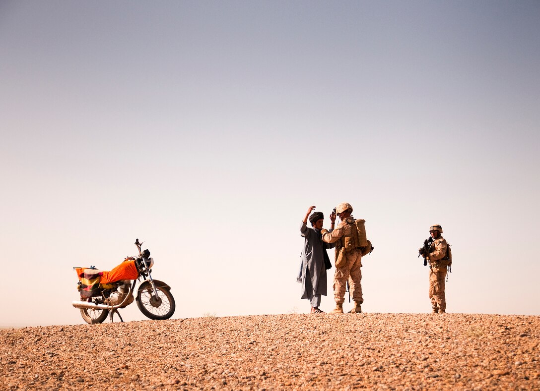 Seaman David R. Trevino, a corpsman with Lima Company, 3rd Battalion, 3rd Marine Regiment, from San Antonio, Texas, provides security while Cpl. Matthew J. Sandrowski, a team leader with Lima Company, 3/3, from Trumbull, Conn., searches a local Afghan man in Southern Shorshork, Helmand province, Afghanistan, during the second day of Operation Cobra, June 17. The man pulled up in front of the Marines’ observation post to survey what was happening. It turned out the man lived nearby and was just curious. The Marines thanked him for his cooperation. Operation Cobra is a joint operation between Marine Corps units and the Afghanistan National Army to disrupt enemy forces which have been using the sparsely populated region between Marjah and Nawa as a safe haven.