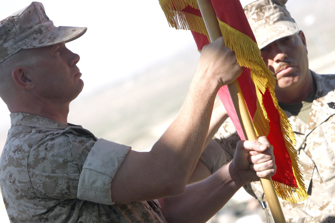 Lt. Col. Timothy G. Burton, the incoming commander of Marine Unmanned Aerial Vehicle Squadron 3, takes hold of the squadron's colors while Sgt. Maj. Rufino Mendez Jr., the squadron's sergeant major, salutes during the change of command ceremony June 17. Burton took over command from Lt. Col. James W. Frey.