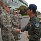 KUNSAN AIR BASE, Republic of Korea -- Col. Jae Hun Choi, 38th Fighter Group commander, presents Cadet Kevin Fernandez a coin during an Operation Air Force program visit here June 11. Operation Air Force is a three-week summer course given to USAFA and ROTC cadets to expose the cadets to the real operational Air Force.  (U.S. Air Force photo/Courtesy Photo)