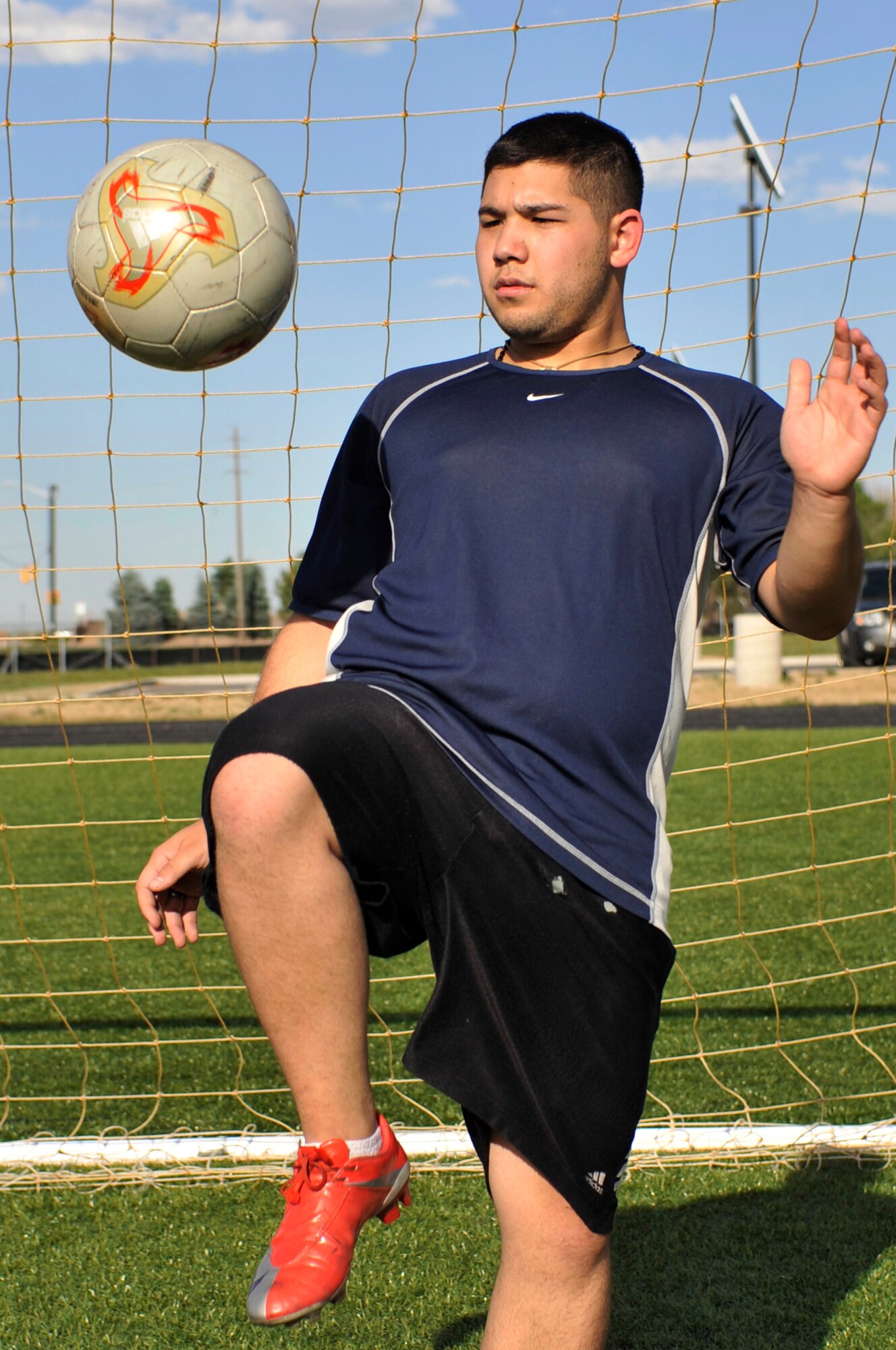 BUCKLEY AIR FORCE BASE, Colo. -- Airman 1st Class Nolan Luna-Chavez, 460th Space Communications Squadron, bounces a soccer ball on his knee to stay agile. No matter what the season's outcome, Airman Luna-Chavez says he still maintains good sportsmanship and respects his fellow athletes. (U.S. photo by Airman 1st Class Paul Labbe)