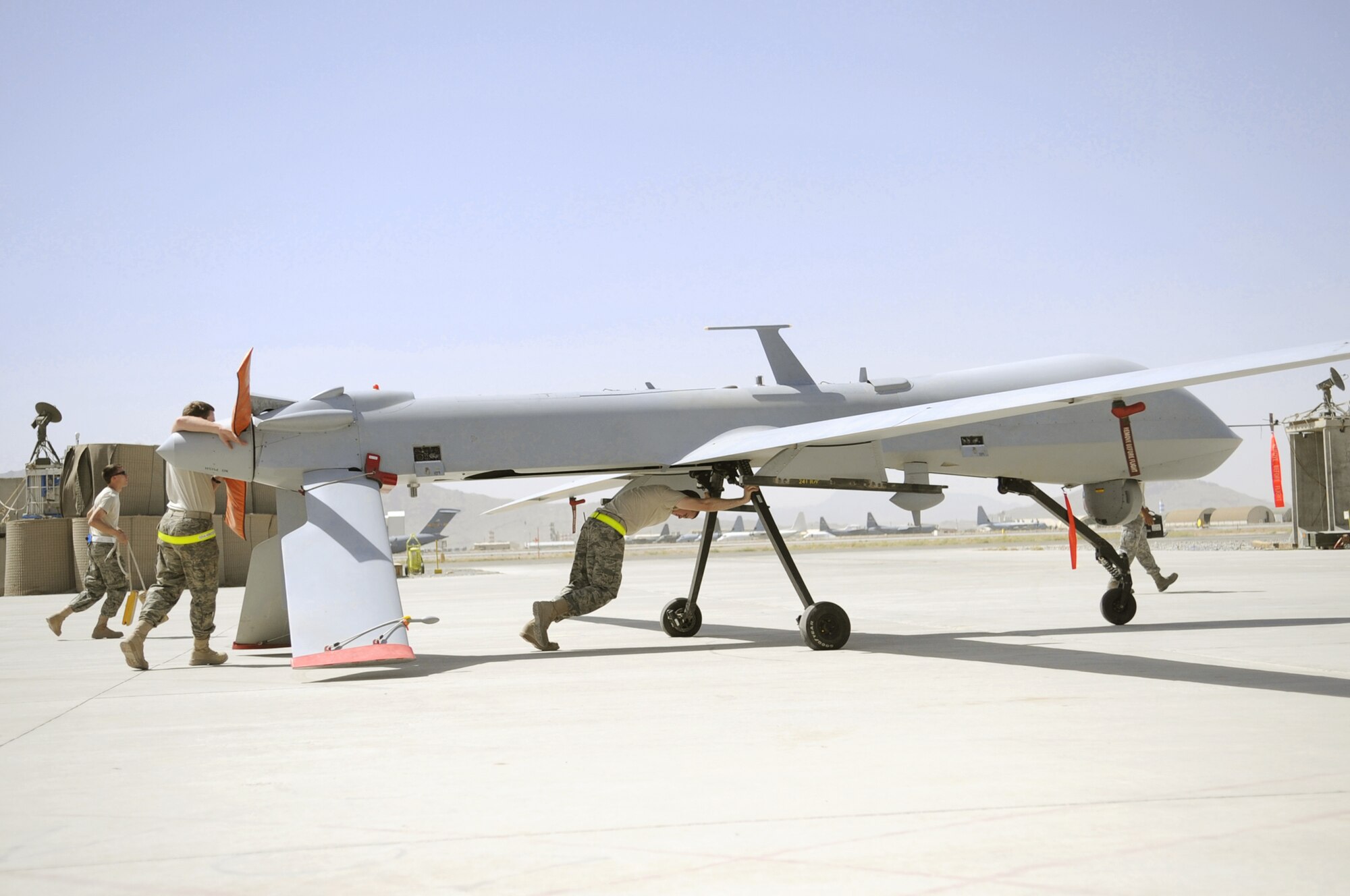 Members of the 451st Expeditionary Aircraft Maintenance Squadron unit push an MQ-1 Predator toward a hangar for a routine maintenance inspection shortly after landing June 8, 2010, at Kandahar Airfield, Afghanistan. (U.S Air Force photo/Senior Airman Nancy Hooks)