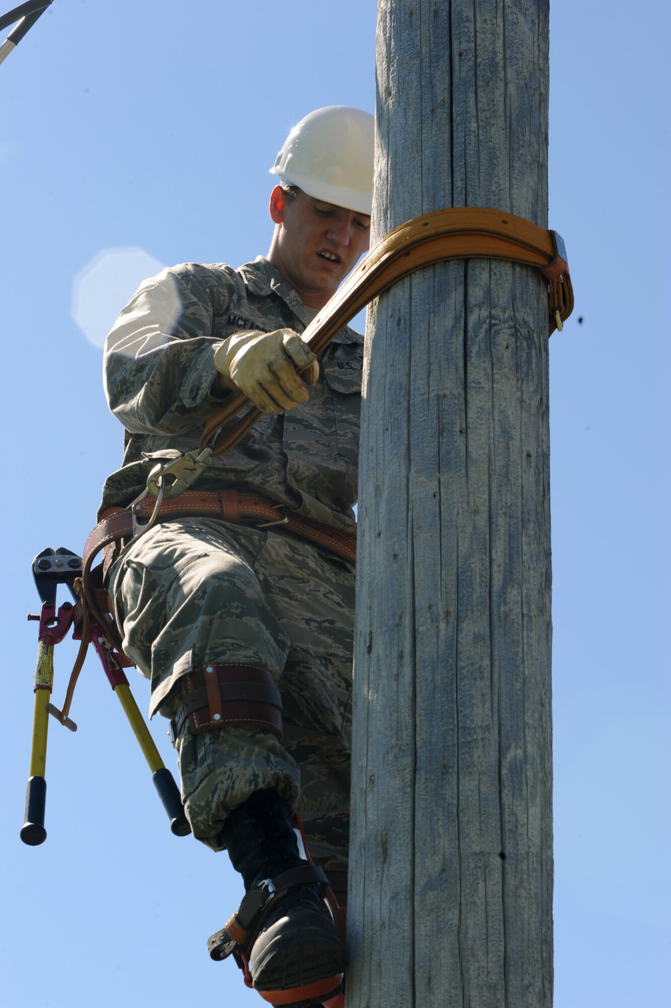 Airman 1st Class Patrick McFadden, an electrical systems apprentice with the 319th Civil Engineer Squadron, watches his step as he continues to climb up an old telephone to deconstruct telephone lines here June 16. The 319 CES is in the process of deconstructing the old telephone pole lines due to the fact base telephone lines are now buried. (U.S. Air Force photo by Airman 1st Class Amber Price)