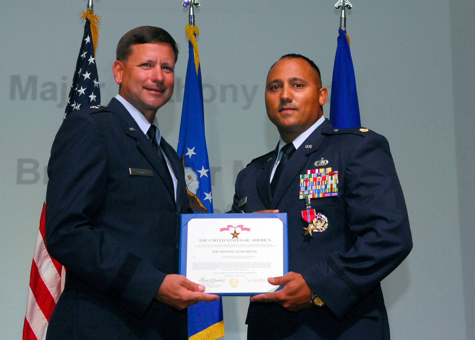 Brig. Gen. Leonard Patrick, 502nd Air Base Wing commander, presents Maj. Anthony Diaz, 802nd Contracting Squadron, with a Bronze Star during the 502nd ABW commander's call June 14. (U.S. Air Force photo/Alan Boedeker)