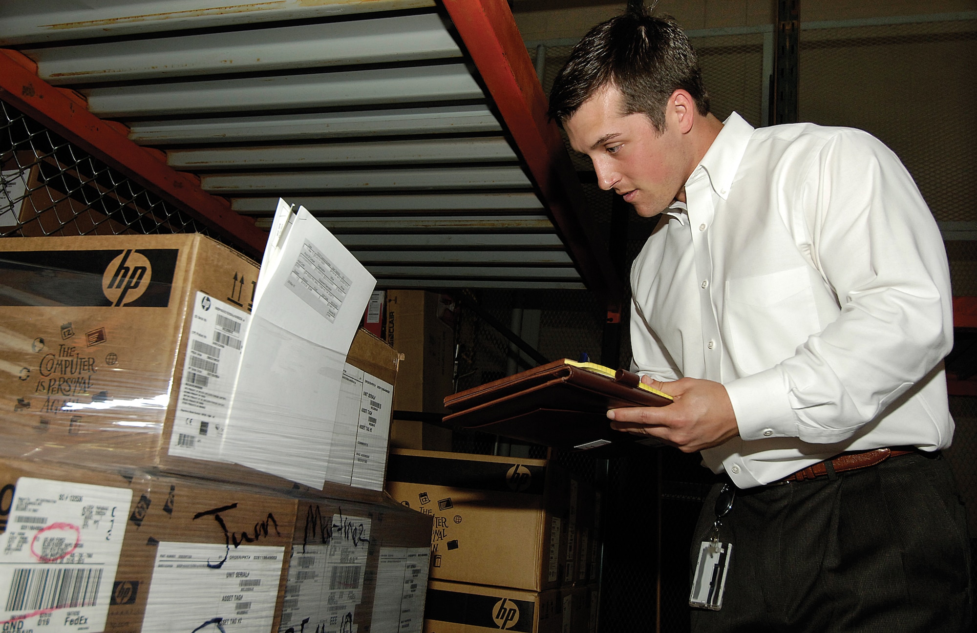 Taylor Lamar checks records, verifying equipment in a 72nd Air Base Wing supply warehouse.  Auditors may specialize in certain areas but all are cross trained to audit areas from the golf course to propulsion, and the chapel to small arms weapons. (Air Force photo by Margo Wright)