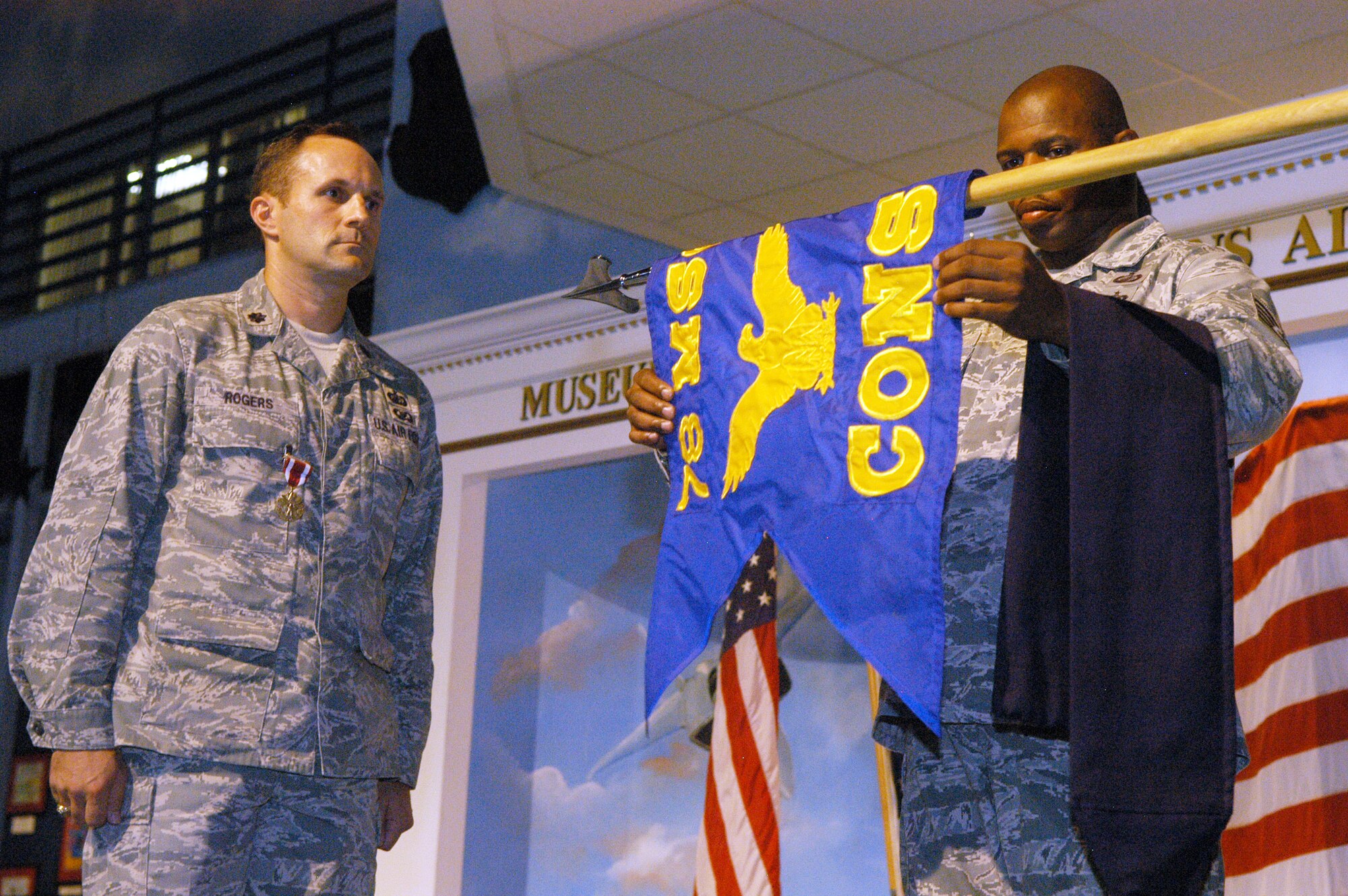 Lt. Col. Christopher Rogers stands at attention as the guidon for the 78th Contracting Squadron is furled by SMSgt. Gregory Brown. U. S. Air Force photo by Sue Sapp