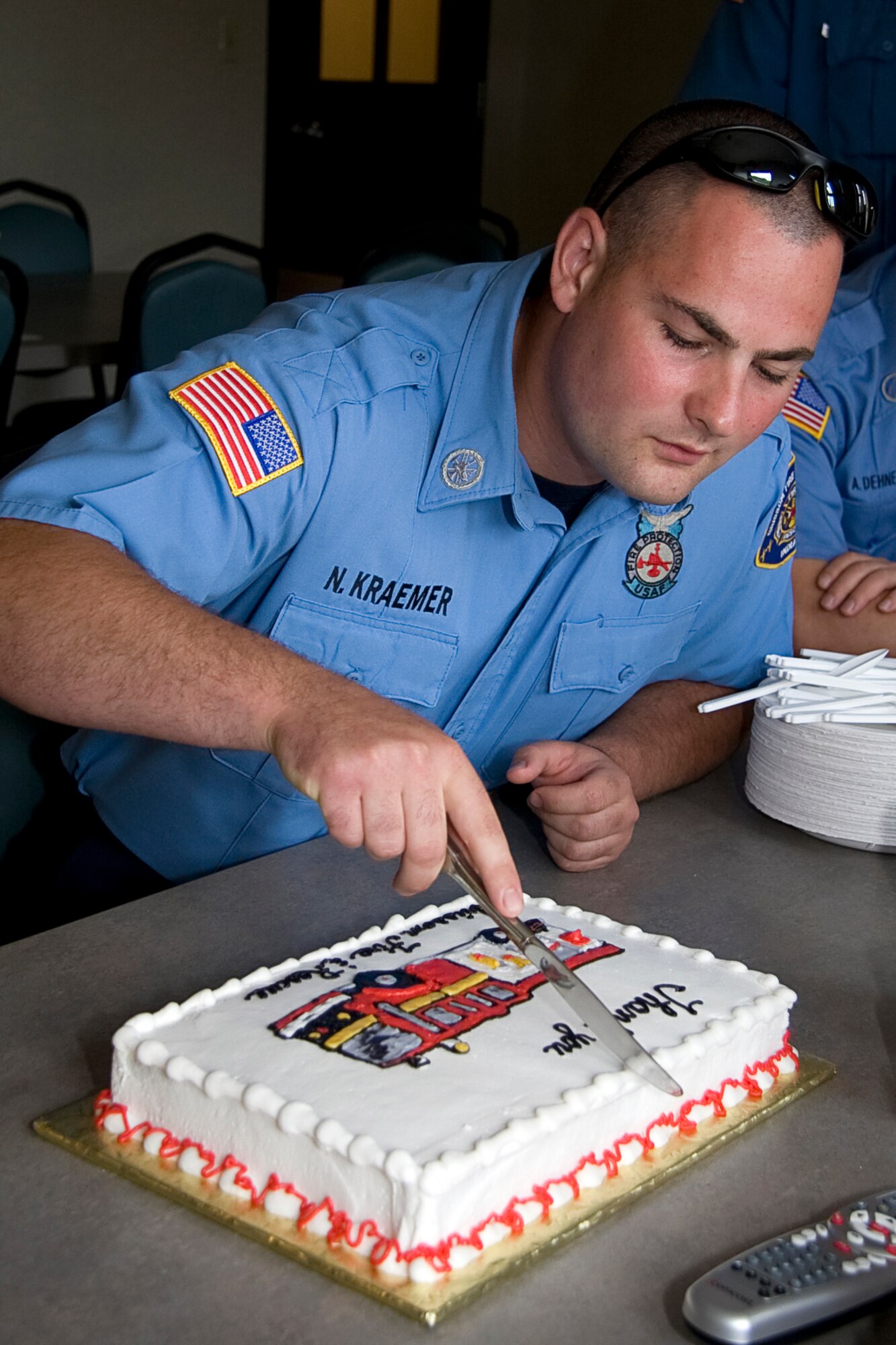 GRISSOM AIR RESERVE BASE, Ind. -- Nathan Kraemer cuts into a homemade cake brought in by Rita Lawrence and her family during a recent visit to the Grissom Fire Department. Mrs. Lawrence came to Grissom to thank Grissom firefighters for saving her life.  Grissom's emergency responders often go off base, providing life-saving services to the local community. (U.S. Air Force photo/Tech. Sgt. Mark R. W. Orders-Woempner)