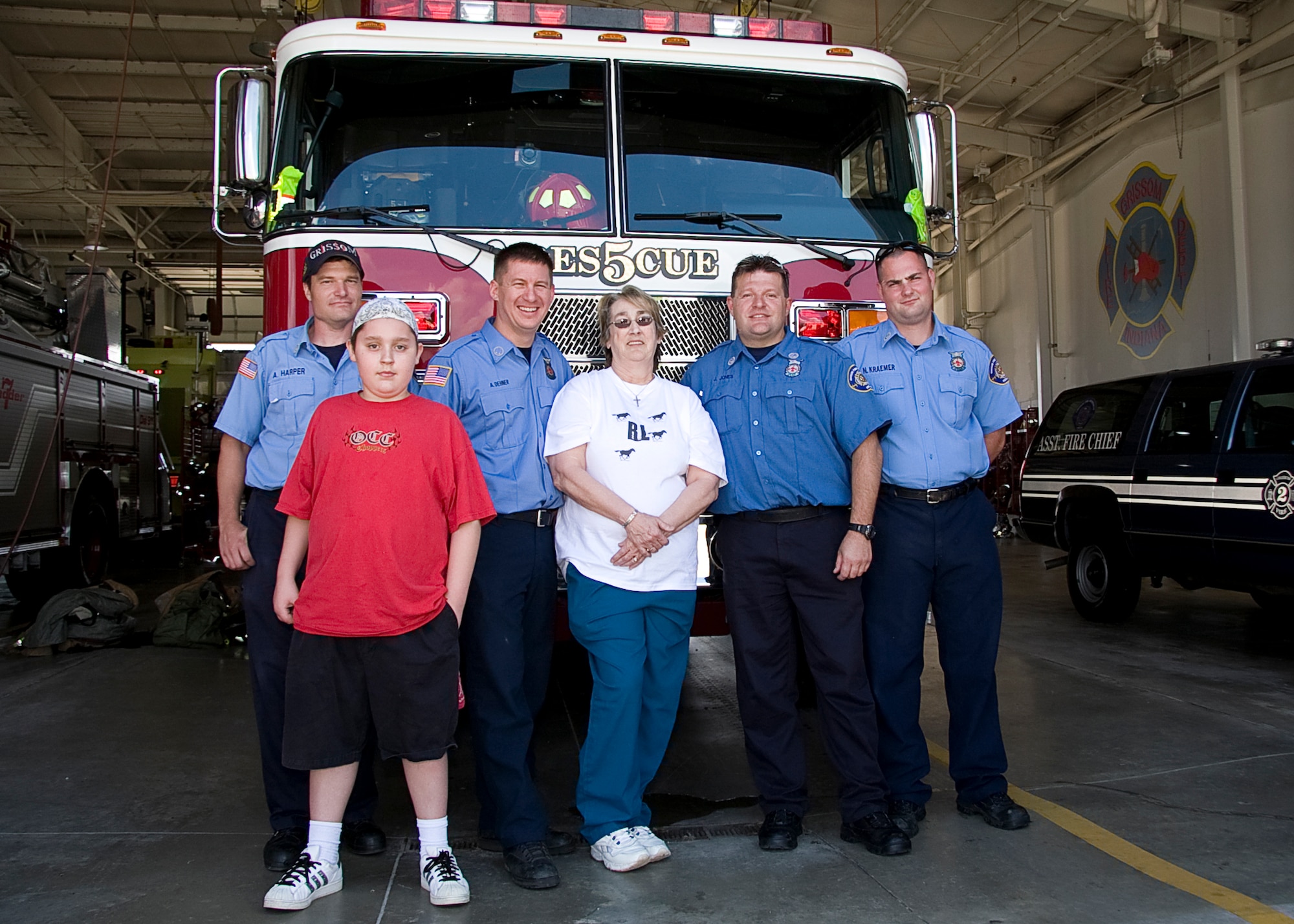 GRISSOM AIR RESERVE BASE, Ind. -- Grissom firefighters, from left to right, Anthony Harper, Aaron Dehner, James Jones and Nathan Kraemer pose for a photo with Rita Lawrence and her grandson Brandon Lawrence in front of Rescue 5. Mrs. Lawrence and her family visited the fire department recently to thank Rescue 5's crew who saved her life. Without Grissom's expert care and quick response, Mrs. Lawrence said Brandon wouldn't have a grandma anymore. (U.S. Air Force photo/Tech. Sgt. Mark R. W. Orders-Woempner)