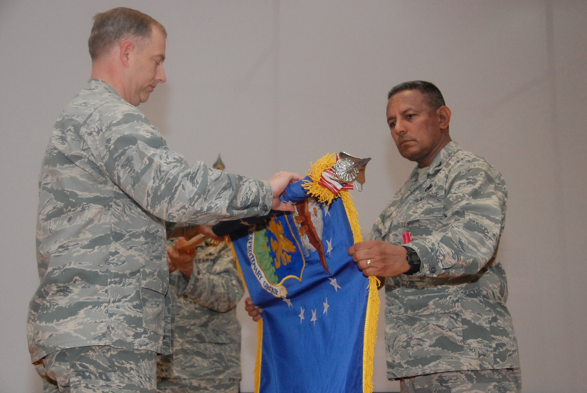 SOUTHWEST ASIA - From left, Col. John R. Gordy II, 386th Air Expeditionary Wing commander, and Col. Jorge Acevedo, the last 586th Air Expeditionary Group commander, furl the 586th AEG guidon during the group's inactivation ceremony here June 17, 2010 at an undisclosed air base. (U.S. Air Force photo by Staff Sgt. Lakisha A. Croley/Released)  