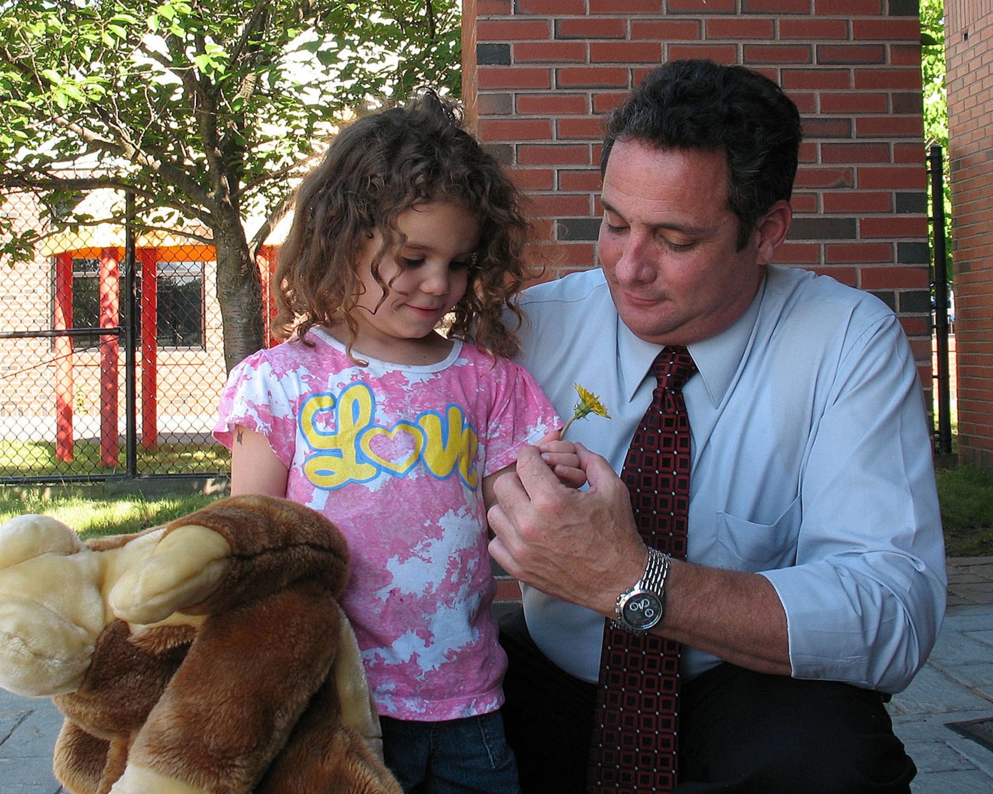 HANSCOM AIR FORCE BASE, Mass. – Carleigh Franzoni gives her dad, Mark Franzoni, a flower for Father’s Day when he picks her up at the Child Development Center on June 15. What Carleigh loves most about her dad, she said, is, “He likes to hug me.” (U.S. Air Force photo by Linda LaBonte Britt)