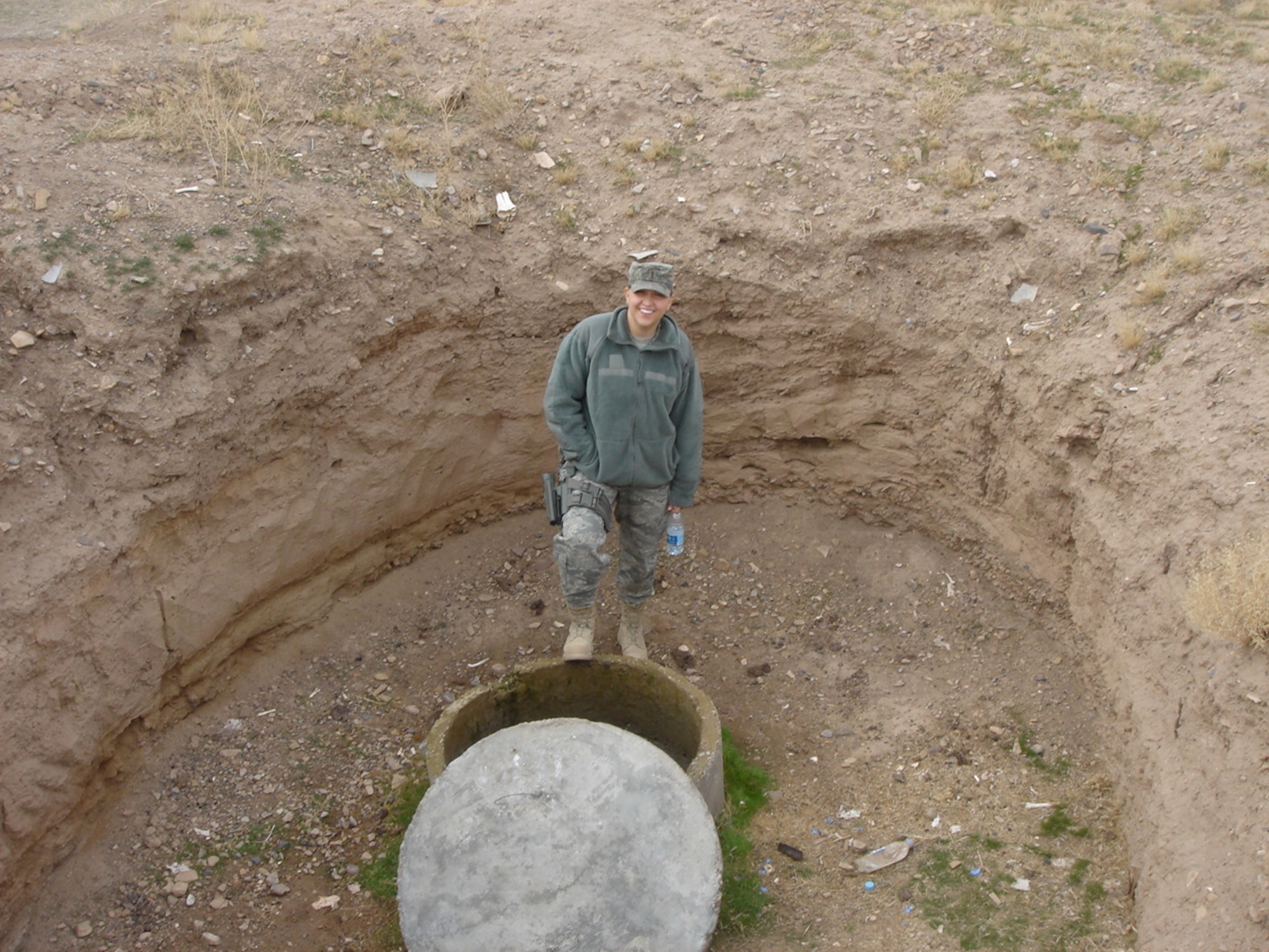 SOUTHWEST ASIA -- Second Lt. Sarah Bodenheimer, 375th Civil Engineer Squadron, stands above a karez - a part of an ancient water system, in Afghanistan. She inspected several of these while deployed in addition to overseeing millions of dollars worth of construction. (Courtesy photo)