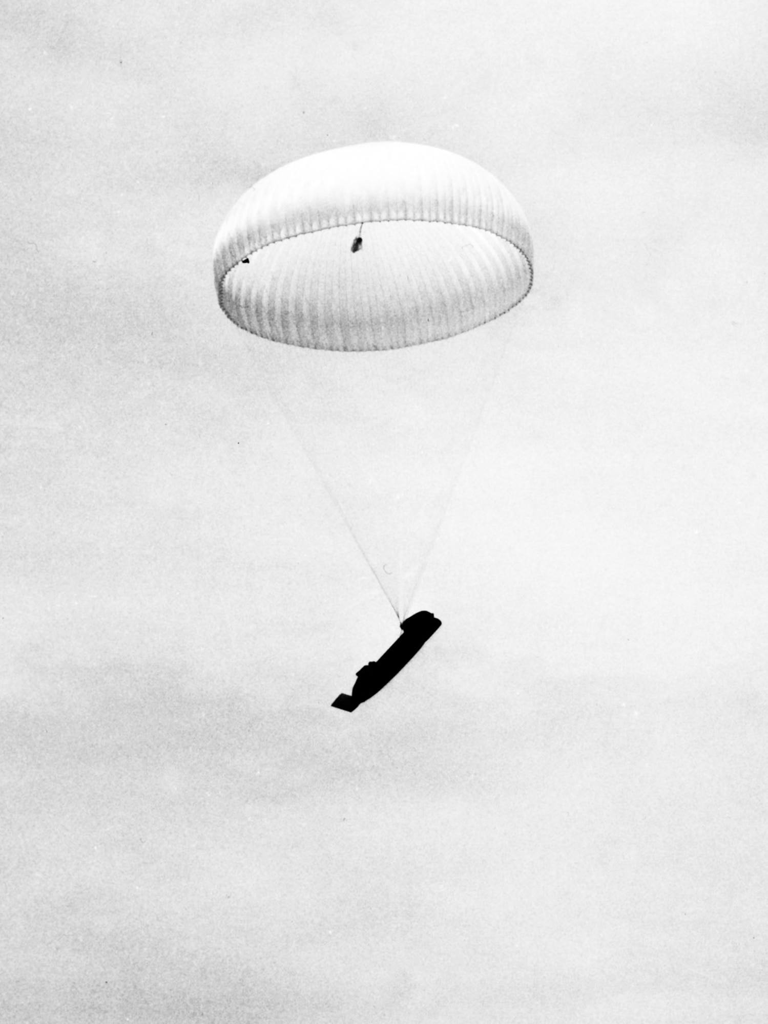 The 100-foot main parachute slows the 1.5-ton boat’s descent. (U.S. Air Force)