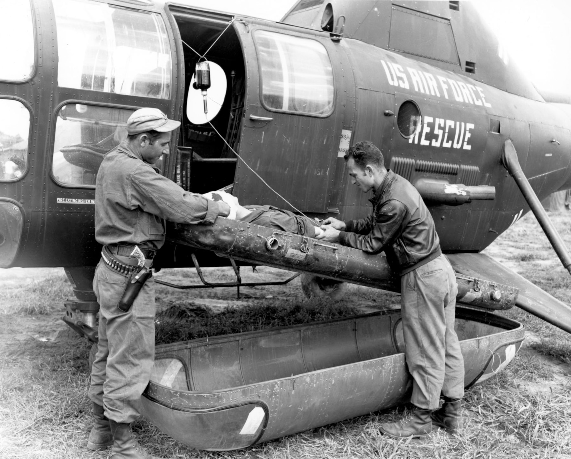 An Air Rescue Service crew treats a wounded UN soldier on one of an H-5G helicopter’s two outboard litters. Note the whole blood hanging in the door, and the litter cover on the ground. (U.S. Air Force photo)