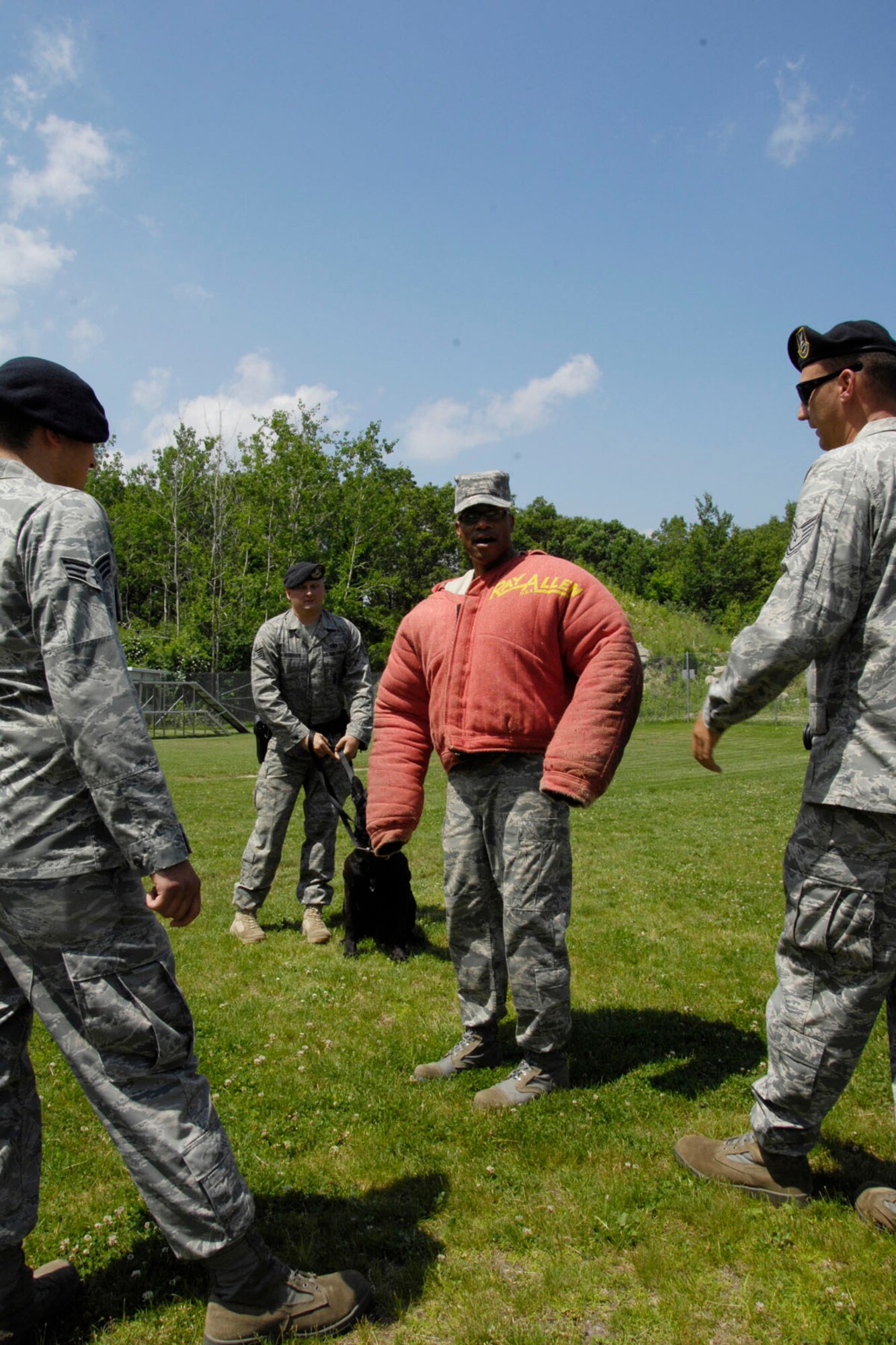 HANSCOM AIR FORCE BASE, Mass. – Chief Master Sgt. Kenneth A. Williams (center), Command Chief Master Sergeant for the Electronic Systems Center, prepares to participate in a military working dog demonstration as Senior Airman Daniel Koski (left), Staff Sgt. Christopher Stidham and Tech Sgt. Andrew Limes give instruction. Chief Williams recently visited the military working dogs and their trainers to learn more about what they do here and throughout New England. (U.S. Air Force photo by Linda LaBonte Britt)
