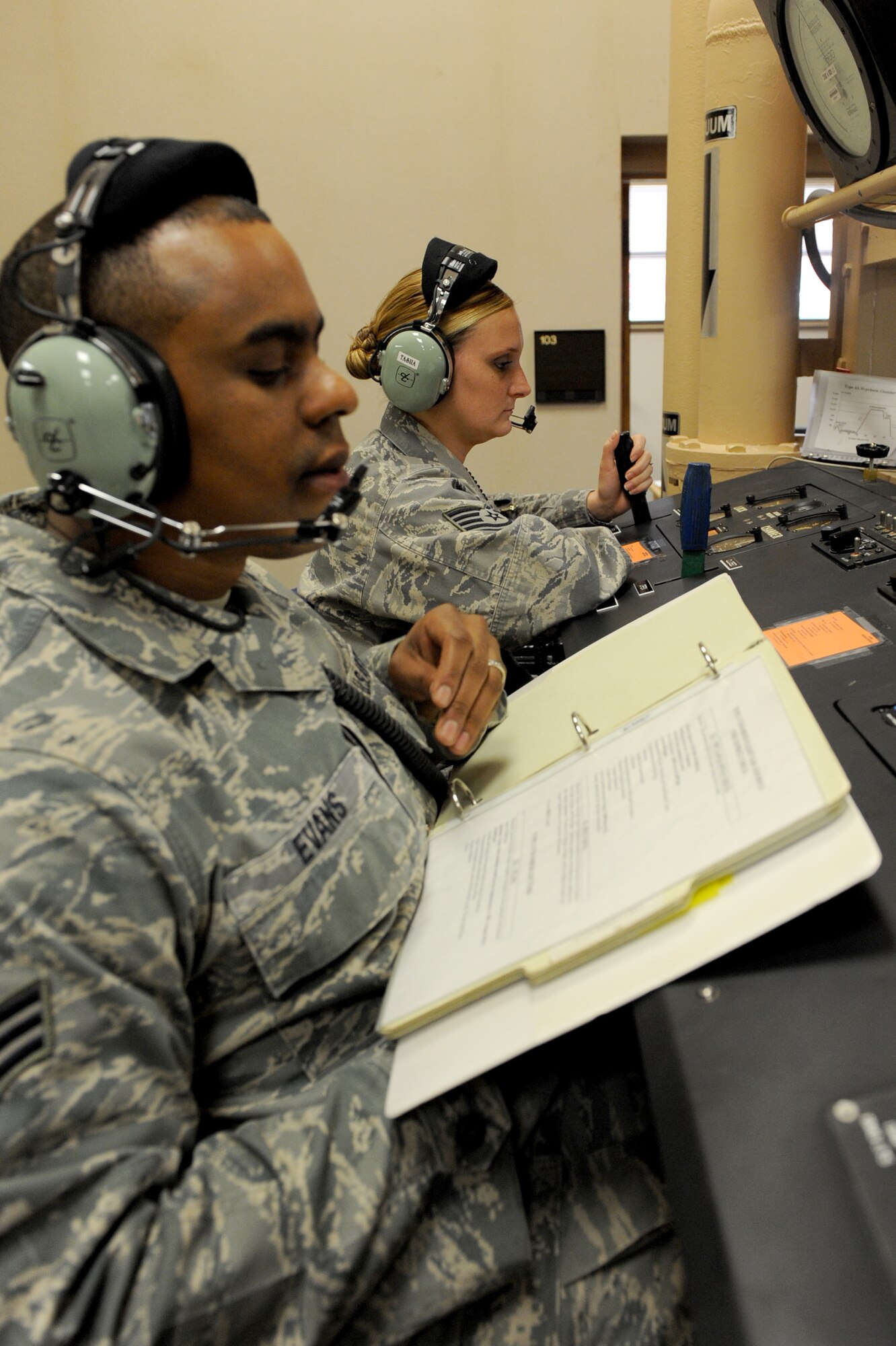 Senior Airman Brian Evans, a 19th Medical Group high-altitude airdrop mission support technician, walks an Airman through the tasks needed to accomplish in order to complete their chamber flight training June 11. The flight chamber staff certifies 500 airmen annually. (U.S. Air Force photo by Senior Airman Ethan Morgan)