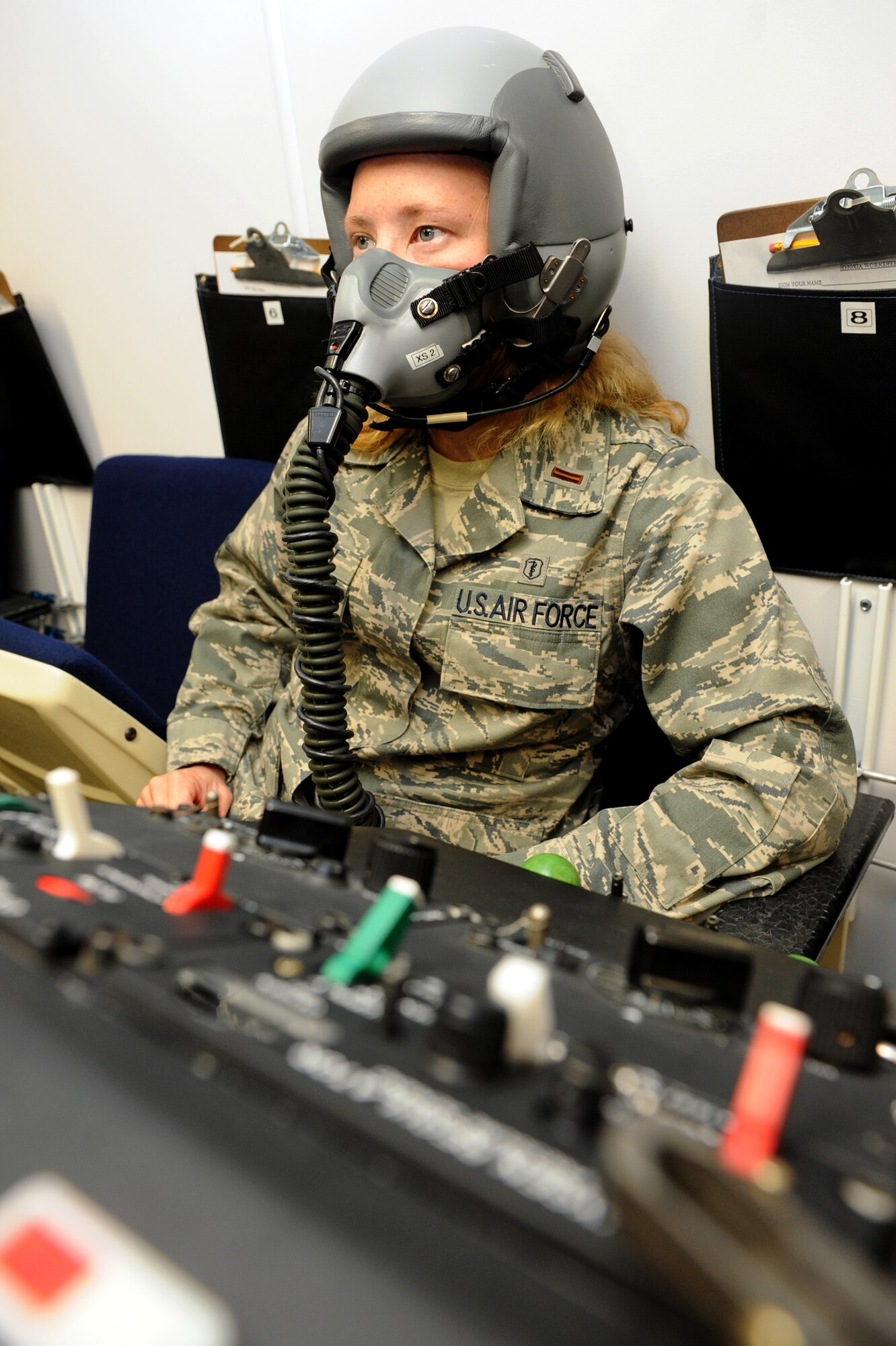 Second Lt. Carmen Gulley, a 19th Medical Group student, is walked through tasks needed to complete her chamber flight training course June 11. Lieutenant Gulley is hooked up to a chamber regulator console which ensures she has a constant air supply during her chamber flight. (U.S. Air Force photo by Senior Airman Ethan Morgan)