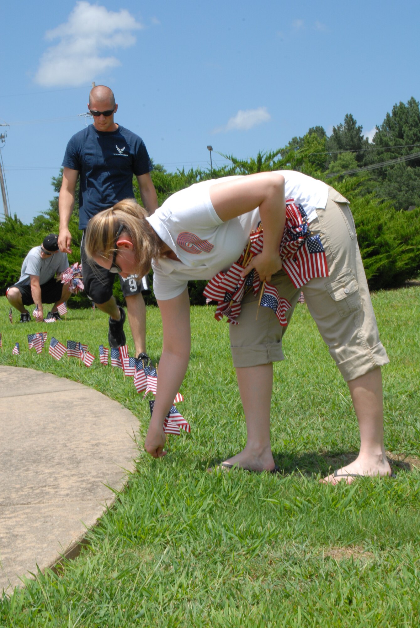 Staff Sgt. Megan Stockinger, 19th Airlift Wing military justice paralegal, sets up a flag display June 13 at Heritage Park. The flags serve as a reminder that the base’s mission has a greater and more historic value than people think about in day to day operations. (U.S. Air Force photo by Airman 1st Class Rochelle Sollars)