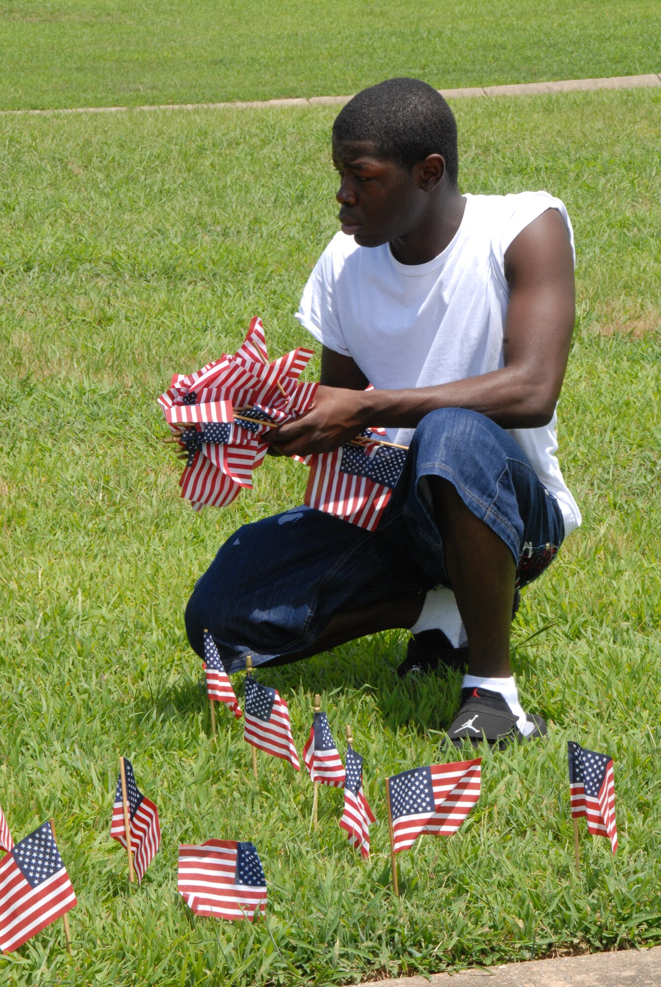 Airman 1st Class Ravon Grant, 19th Logistics Readiness Squadron customer service, sets up flags June 13. The flags symbolize the patriotism that exists at Little Rock Air Force Base. (U.S. Air Force photo by Airman 1st Class Rochelle Sollars)