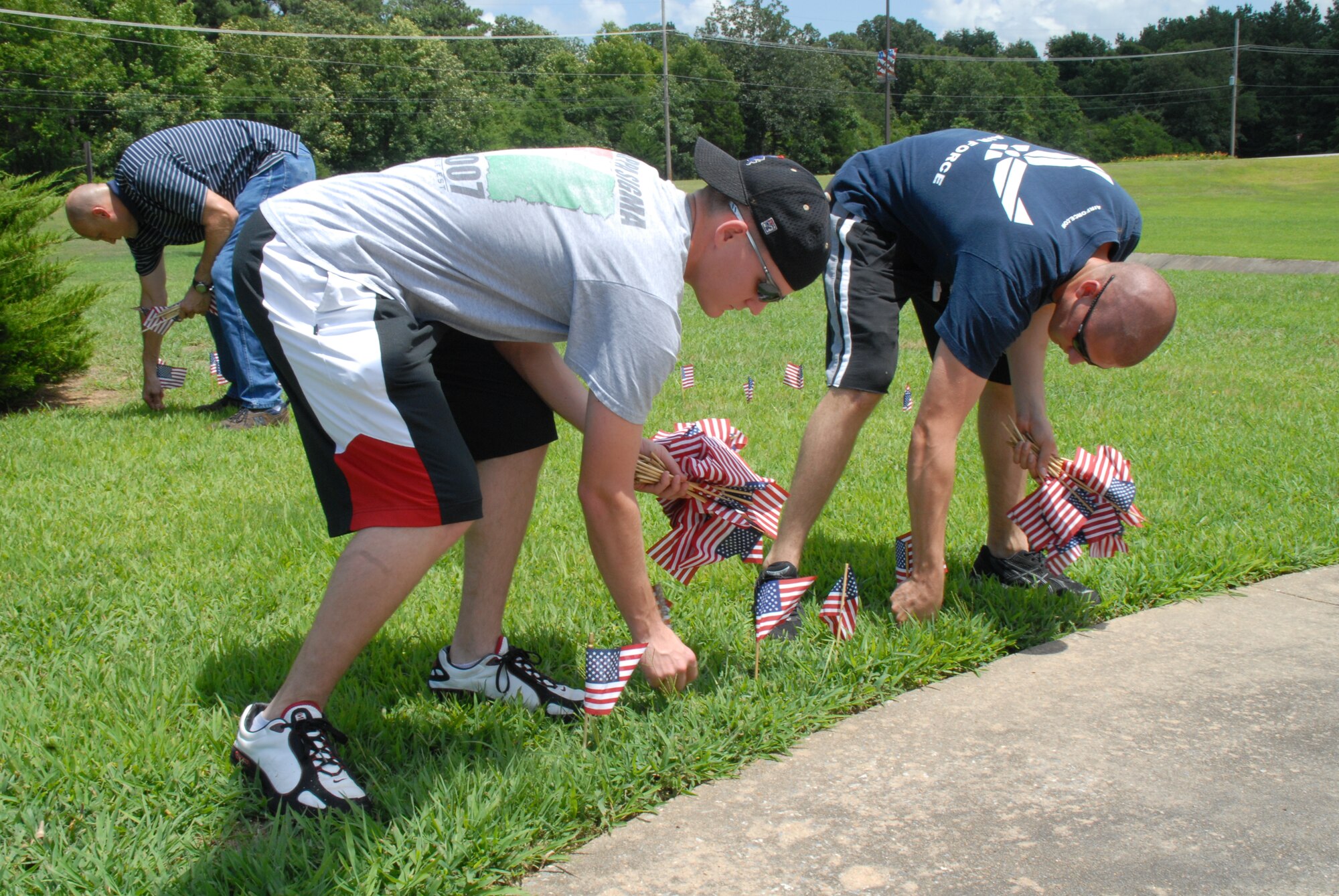 Airman 1st Class Ryan Flowers, 19th Logistics Readiness Squadron customer service, and Airman 1st Class Jared Inbody, 19th Aircraft Maintenance Squadron avionics, set up a flag display June 13 at Heritage Park. Shortly after World War II, President Truman signed an act of Congress that officially designated June 14 as National Flag Day. (U.S. Air Force photo by Airman 1st Class Rochelle Sollars)