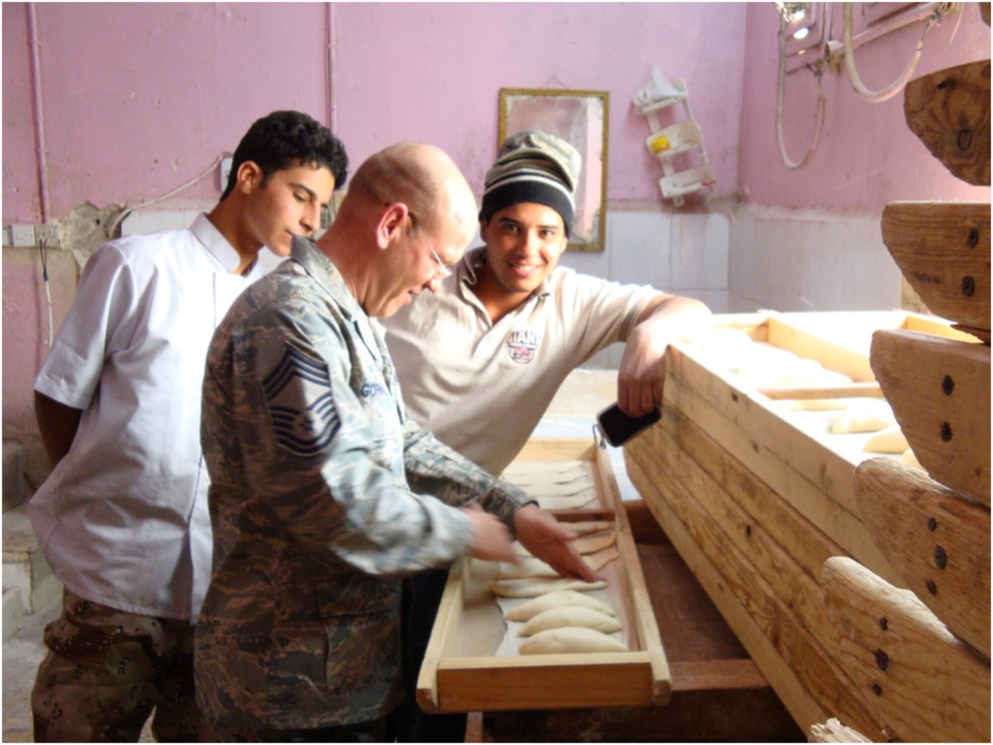 Chief Master Sgt. Richard Gornal, 732nd Expeditionary Logistics Readiness Squadron, kneads bread with Iraqi bakers the Iraqi Army Kirkush Military Training Base, Iraq, April 2009. (U.S. Air Force photo)