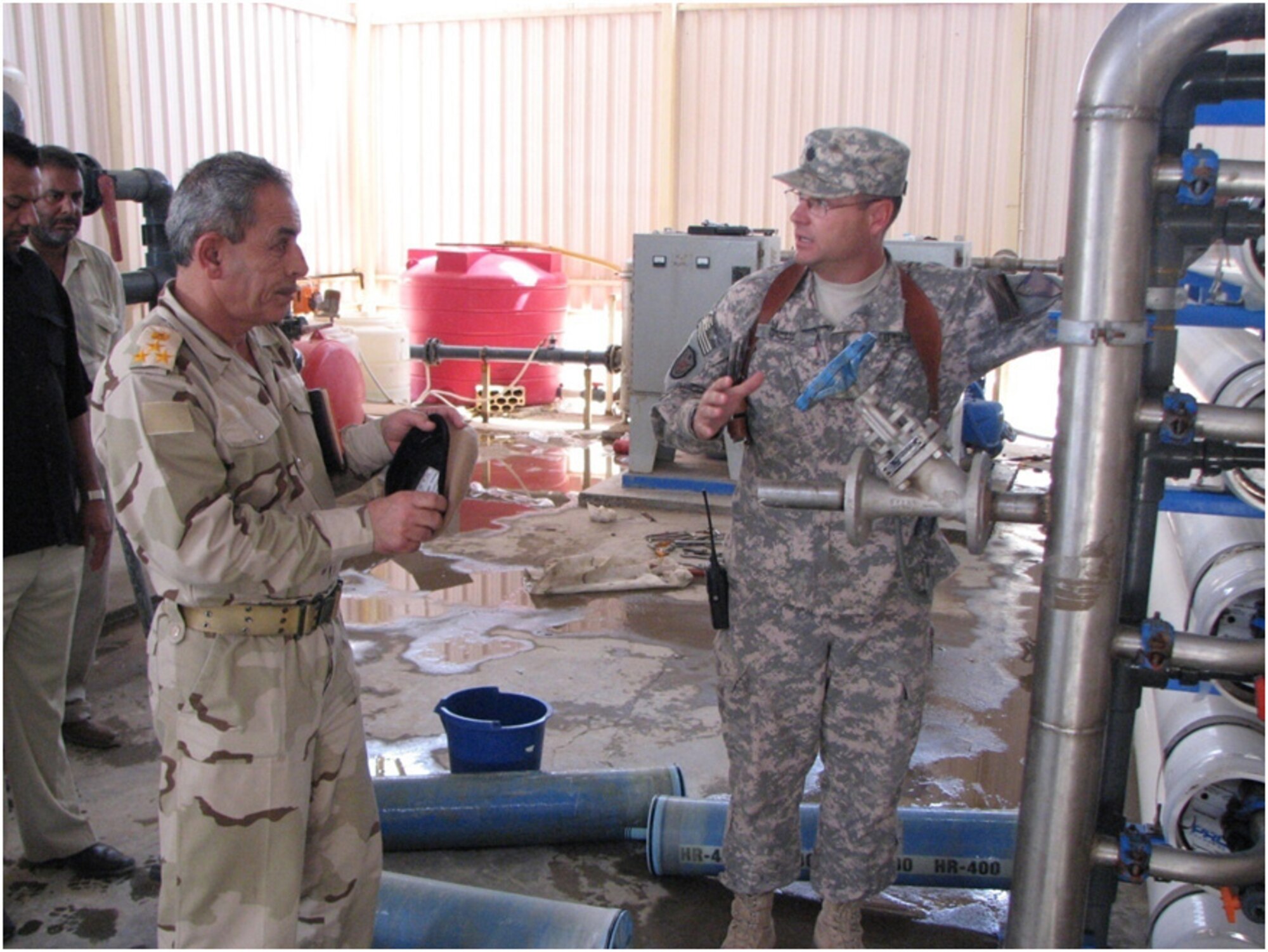 Lt. Col. Steven Ramsay, 732nd Expeditionary Logistics Readiness Squadron and the senior adviser with the Tallil Logistics Military Advisory Team, discusses water treatment equipment with an Iraqi Army officer at Iraqi Army Camp Ur, Iraq, September 2009. (U.S. Air Force photo)