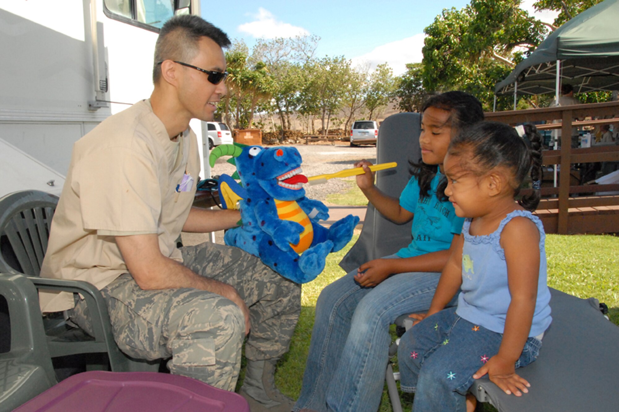 Maj. Simon Nguyen, a dentist with the 178th Medical Group, Ohio Air National Guard, uses an instructional puppet to teach young patients how to maintain good dental hygiene June 8 at Pu’ukohola Heiau National Historic Site, Kona, Hawaii.  The 178 MDG is on a training deployment in which it provides free medical services to underserved communities that do not have access to healthcare on the island.
