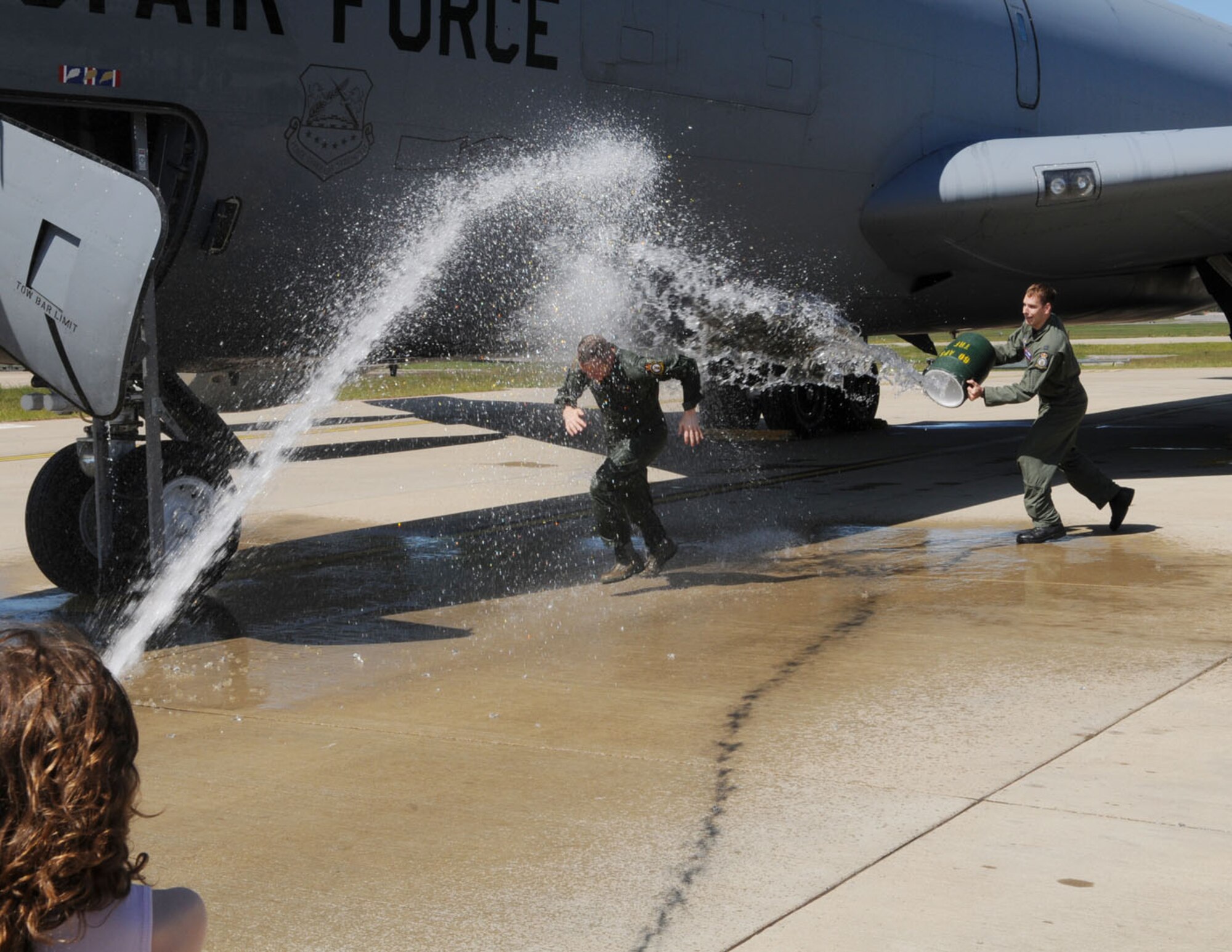 Col. Creg Paulk, center, 100th Operations Group commander, attempts to make a run for it as he receives a full-on soaking from his daughter, Olivia, 7, left, son, Dalton, 11 (not pictured), and Capt. Jordan Kemp, right, 351st Air Refueling Squadron, after his fini flight June 16. Colonel Paulk and his family are heading to Washington D.C., where he will take up his position at the Pentagon as Chief, NORTHCOM/SOUTHCOM Division, Air Force International Affairs. (U.S. Air Force photo/Karen Abeyasekere).